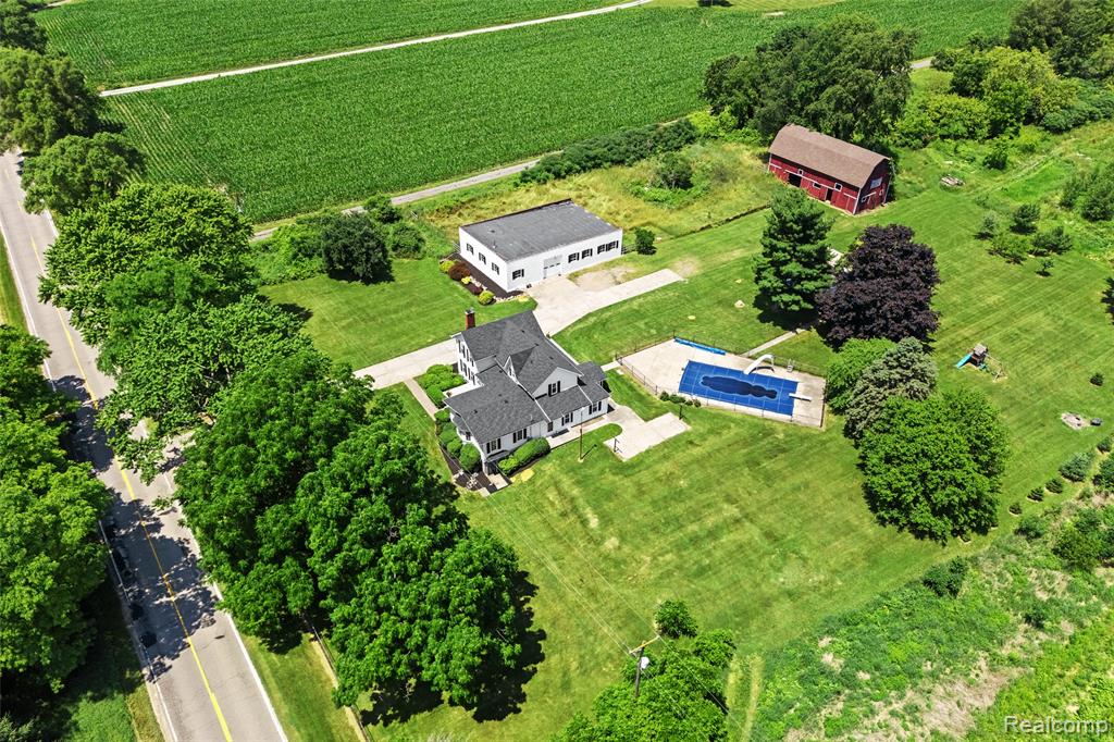 Welcome to this beautifully restored and lovingly maintained farmhouse, set on 4 picturesque acres in the sought-after Hartland School District. This warm and inviting home offers four spacious bedrooms and two and a half bathrooms, providing ample space for both everyday living and entertaining. Inside, you'll find a cozy family room with a wood-burning fireplace and a bright, airy living room with a gas fireplace—both perfect for gathering and relaxing.

The kitchen is a true centerpiece, featuring granite countertops, stylish fixtures, a generous breakfast nook, and easy access to a formal dining room that’s ideal for hosting friends and family. A large main floor laundry room, excellent closet space, and thoughtful built-in details and cubbies throughout add to the home’s functionality and charm. Sunlight pours into every room, highlighting the home's welcoming and cheerful atmosphere.

Step outside to enjoy your private outdoor oasis, complete with an in-ground pool that includes a slide, diving board, and secure fencing—ready for summer fun. The property also features a barn, a solid block building that can be used as a garage or workshop, and a convenient pool house. Whether you're looking for storage, work-from-home space, or room for hobbies, this property has it all.

With no HOA, no dirt roads, and a peaceful setting that includes several fruit trees—apple, peach, and pear—this home offers the best of rural living with modern comforts. Don’t miss your opportunity to experience the lifestyle this exceptional farmhouse has to offer.