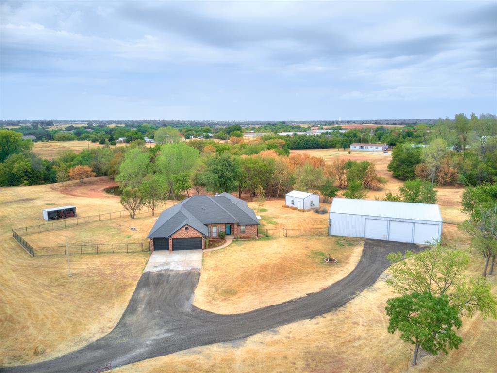 Enjoy peaceful country-style living right in town on 5 beautiful acres with gorgeous views and a private pond! This 4-bedroom home features an impressive list of updates, including a geothermal HVAC with hot water generation, new exterior paint, updated appliances, wine fridge, custom concrete countertops, custom tile work, LifeProof LVP flooring, fresh paint, hardware and fixtures. Outside, enjoy the large covered back porch, outdoor griddle kitchen/bar, hot tub hookup, fenced backyard, raised garden beds and plenty of room to spread out. Property also includes a 40x60 shop with water and electric, a 20x20 heated and cooled shop with electric, lean-to building, aerobic system and private well. A rare opportunity to enjoy acreage, views, a pond and incredible amenities—all while staying conveniently in town!