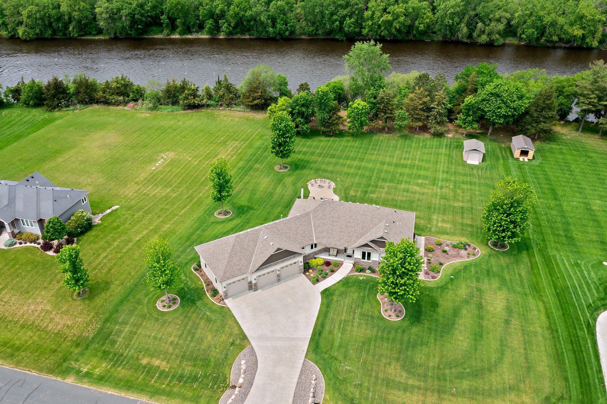 Welcome to this custom-built home, where no detail was overlooked and every aspect has been meticulously crafted to offer unmatched comfort and style. From the moment you step inside, you are greeted by a vast, open-concept living space. The 13' vaulted ceilings soar overhead, creating a sense of openness, while an abundance of windows allows natural light to flood the home and offers sweeping views of the backyard. The living room is anchored by an impressive floor-to-ceiling gas fireplace. The sunlit room casts a soft glow over the engineered hardwood floors. The kitchen features stunning granite countertops, rich cherry wood cabinets, and a generously sized center island. A spacious pantry ensures you have ample storage, while the adjacent buffet area offers additional cabinetry and counter space. The dining room offers a perfect setting for both casual and formal dining. Glass doors open directly to the maintenance-free deck, where you'll enjoy tranquil views of the expansive backyard. A gas line to the grill adds convenience for outdoor entertaining. The primary suite offers serene views of the backyard, an ensuite bathroom featuring a large walk-in tiled shower and a soaker tub as well as a large walk-in closet. Two additional well-sized bedrooms are also located on the main floor, each offering plenty of closet space. A full bathroom with a granite vanity and linen cabinet serves these rooms. Practicality is never compromised in this home, as evidenced by the main level mudroom, located just off the garage and includes a coat closet, along with a half bathroom & laundry room complete with a sink and cabinetry. In the lower level, you’ll find a large family room that is perfect for entertaining which features a stone surround gas fireplace with built-in cabinetry providing plenty of storage. Two additional spacious bedrooms are located downstairs, each featuring its own walk-in closet. The in-floor heat in the lower level 3/4 bathroom provides warm for relaxing experience. Access to the lower level is also available directly from the garage adding convenience for those coming in and out of the garage or yard. The lower level is also home to the spacious wet bar providing seating for guests while entertaining. A geo-thermal HVAC system with dual zones, ensures both comfort & energy efficiency. The home also boasts a Calcium Injection System for the irrigation system, keeping your lawn lush and beautiful. The finished, insulated & heated garage is huge and features a floor drain, 220-amp service, and a water spigot for added utility. New washer and dryer units were installed in 2024. Outside, the large paver patio, complete with a firepit, offers a perfect place to enjoy the outdoors. The 16x12 storage shed provides ample space for more storage. The home sits on just over an acre of beautifully landscaped grounds. Located in a peaceful, 17 home neighborhood, this property offers access to Lily Pond Park, Norin Landing Park, and a boat launch just down the road. Additionally, a private swimming pond and beach are just across the street. A short golf cart ride takes you to Riverwood National Golf Course, while daily sightings of majestic bald eagles make this property feel like a true sanctuary.