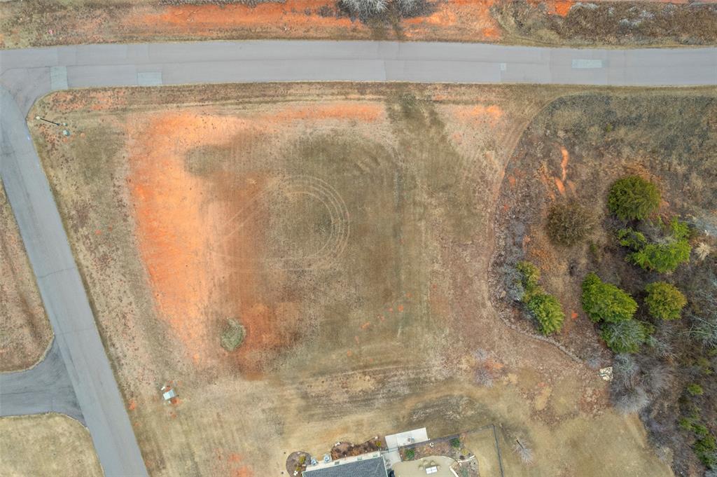 Rare opportunity to build in highly sought-after Manor Lake Hills! This premier gated community offers peaceful luxury just 15 minutes from Downtown Norman. One of the final homesites available, this prime 2+ acre corner lot sits at the top of the hill, offering privacy, sweeping views, and breathtaking Oklahoma sunsets.

The wide frontage allows ideal placement for a side or rear-entry garage, while the depth of the lot provides room for a grand front facade and circular drive. With generous space for your custom residence, pool, outdoor living, shop, or extended driveway layout, the property offers exceptional flexibility to create an estate-style home. Mature natural surroundings enhance the tranquil feel.

Neighborhood amenities include scenic walking trails, a stocked fishing pond, community pool, and clubhouse. Near shopping, dining, entertainment, and highway access, this location offers the perfect blend of space, beauty, and convenience. Don’t miss this chance to secure one of Norman’s most desirable remaining lots—ready for your vision.