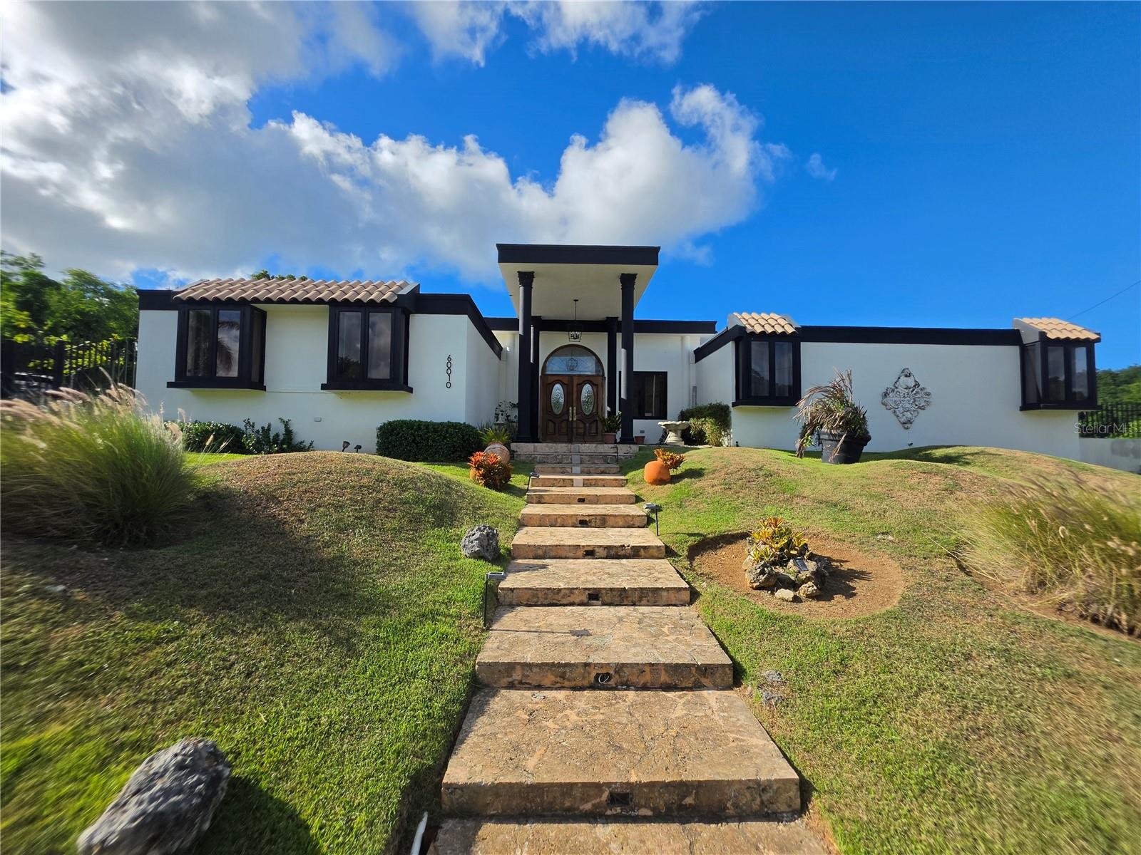 Exquisite and Spacious Residence in Exclusive Urb. Bosque Dorado!Situated on an oversized, beautifully landscaped 0.52-acre lot (approximately 2,090 sq. mt.) tucked away at the end of the street, this stunning residence offers 2,848 sq. ft. of heated living space, featuring an open-concept floor plan filled with natural light, 4 bedrooms, 2.5 bathrooms, and an additional full bathroom conveniently located by the pool.The magnificent primary suite is a true private retreat, featuring two enormous walk-in closets and a luxurious en-suite bathroom. Designed for ultimate comfort and entertaining, the home boasts an expansive family room and a fully remodeled, modern kitchen equipped with high-end quartzite countertops, an extra-large refrigerator, a stove with oven, and a reverse osmosis water filtration system. The elegant design creates a seamless indoor-outdoor flow, perfect for both everyday living and hosting guests.Step outside to your own private tropical oasis, featuring a gorgeous, sparkling swimming pool and a covered terrace ideal for outdoor dining and relaxation.Additional features include a two-car garage with an EV charging station, six mini-split air-conditioning units, a water heater, an included solar energy system with two Tesla batteries for reliable backup power, a 550-gallon water storage tank, and a water softener.Located in the exclusive, gated community of Urb. Bosque Dorado, this exceptional property offers an outstanding combination of space, comfort, modern amenities, and privacy in a secure residential setting.Don't miss this exceptional opportunity to own a beautiful tropical retreat!