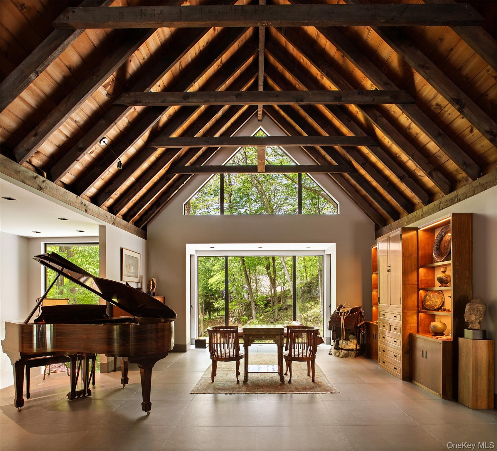 MAGNIFICENT CONTEMPORARY MASTERPIECE
A Fully Renovated/Rebuilt Perfectly Scaled Sanctuary with Indoor Swimming Pool & Exquisite Gardens Inspired by Japanese Design, Just 1 Hour From Manhattan

Elevated on a gentle rise and approached by a long private drive, this modern classic estate offers complete privacy and tranquility in a serene, wooded setting. Nestled among soaring trees, this thoughtfully renovated home masterfully blends contemporary architecture with natural materials, creating warmth and a welcoming atmosphere throughout. Oversized floor-to-ceiling windows flood each room with natural light and frame stunning views of curated gardens inspired by traditional Japanese design, each vista composed like a living painting.

Massive boulders and stone slabs—carefully placed throughout both the landscape and the home—create a sense of harmony from the first approach. The stone path leads to the front door and into a unique architectural oasis. Inside, soaring beamed ceilings and extensive custom millwork define the interiors, beginning with a gracious entry that opens to a generously proportioned living room centered on a monumental, two-story marble-clad fireplace.

A formal dining room overlooks the gardens and connects seamlessly to the heart of the home: a striking, expansive kitchen ideal for intimate gatherings or large-scale entertaining. Anchored by a custom range hood and wrapped in dramatic black marble, the kitchen features professional-grade appliances and sleek cabinetry that merge function with sculptural design.

The principal bedroom suite is perfectly positioned on the main level for effortless living, complete with a beautiful wood-burning fireplace. The lower level offers two additional guest bedrooms, a full kitchen, and a private living room—well separated yet connected by a chic stairway bathed in natural light.

The “pi&#232;ce de r&#233;sistance” a stunning 60-foot indoor heated lap pool with jets and a private sauna, housed in a contemporary pavilion with walls of glass on three sides and an illuminated ceiling. Sliding doors open to an expansive stone terrace accented with sculptural boulders, an ideal setting for alfresco entertaining or quiet reflection.

Each window throughout the home was designed to frame artful views into the surrounding landscape—gardens deeply influenced by Japanese aesthetics. From winding stone paths to a hand-built stream and solid stone bridge, every element is shaped to evoke calm and contemplation. Designed for low maintenance, the garden becomes both sanctuary and spectacle—inviting moments of stillness, beauty, and connection to nature. The property is bordered by two protected preserves—the Goldfine Preserve and the Hale Ravine—offering direct access to peaceful woodlands and scenic trails.

Whether entertaining guests or embracing solitude, this expertly engineered, move-in ready home delivers a lifestyle of elegance, privacy, and wellness. Located just minutes from Bedford Village, Pound Ridge, Katonah, and North Salem—and only an hour from Manhattan—this is a rare opportunity to experience design and nature in perfect harmony.