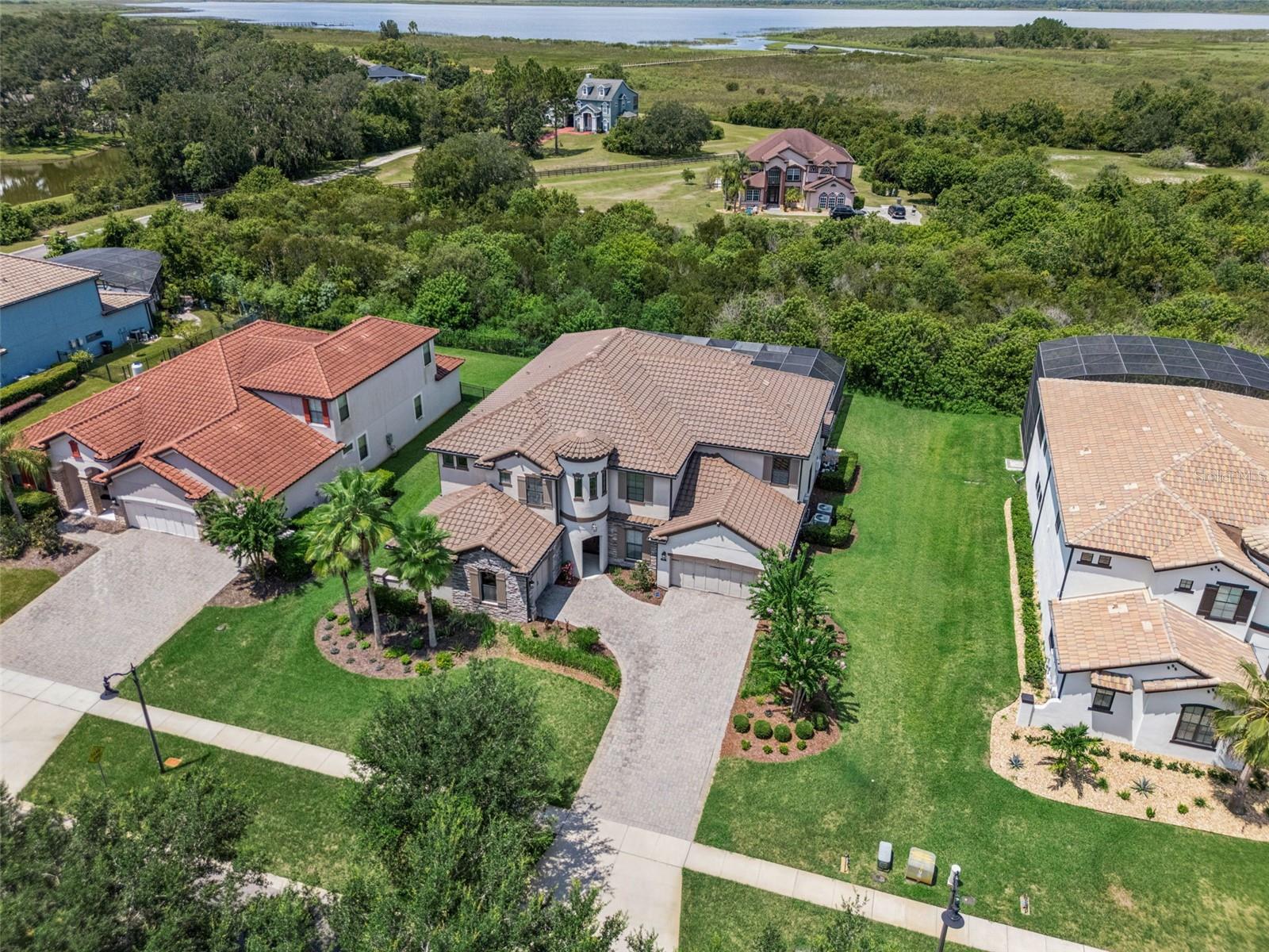 Virtually Staged. Luxury, privacy and LAKE ACCESS define this exceptional 6-bedroom, 5.5-bath CUSTOM POOL HOME in Waterside Vista, an intimate GATED ENCLAVE of just 24 residences in St. Cloud! Set on the largest lot in the community (.69 ACRES!) near the end of a quiet dead-end street, this impressive property offers CONSERVATION VIEWS, no rear neighbors, spacious side yard, no front neighbors (VERY PRIVATE!!) and convenient access to the COMMUNITY BOAT RAMP leading to Fells Cove, East Lake Tohopekaliga and the Toho chain of lakes. A paver driveway, lush landscaping, TILE ROOF and split 3-car garage creates a striking first impression upon your arrival. Inside, endless natural light,  UPGRADED TILE FLOORING and flexible living spaces complement a thoughtfully designed floor plan. The chef-inspired kitchen is built for entertaining with DOUBLE ISLANDS, abundant cabinetry and counter space, GAS COOKTOP, built-in DOUBLE OVENS and a prep/vegetable sink, all open to the light filled breakfast nook and spacious living room. The MAIN FLOOR OWNER’S SUITE enjoys peaceful wooded views, a DUAL-SIDED WALK-IN CLOSET and beautifully appointed private bath. A second downstairs bedroom with en-suite access to a full bath makes an ideal guest suite or office. There is also a flex space available at the front of the home for use as a den, study, or home office. Upstairs are four additional bedrooms, a massive LOFT and dedicated HOME THEATER with projector, screen, speakers and theater equipment included. Three bedrooms feature en-suite baths, while a second-floor laundry chute leads directly to the first-floor laundry room. Tile flooring continues throughout the home with comfortable carpet reserved for the theater, and an additional mini-split A/C provides customized cooling in the primary suite. A wall of sliding glass doors opens to a backyard oasis that feels like a private resort with a luxury pool, gas-heated spa and expanded pool deck, plus pre-plumbing for a future summer kitchen and grill. Upstairs, the SCREENED BALCONY captures gorgeous LAKE AND SUNSET VIEWS beyond the conservation setting. Waterside Vista offers community lake access via a boat ramp just moments away, while its St. Cloud location provides convenient access to Lake Nona, Medical City, Eagle Creek, Boggy Creek Road, SR 417, the Orlando International Airport, shopping, dining and “A” RATED SCHOOLS. Unique design, exceptional privacy, generous versatile living spaces and true Florida luxury come together in a home created for both everyday comfort and unforgettable entertaining. Call today to schedule a tour and let us say WELCOME HOME! ***Seller may consider buyer concessions if made in an offer***