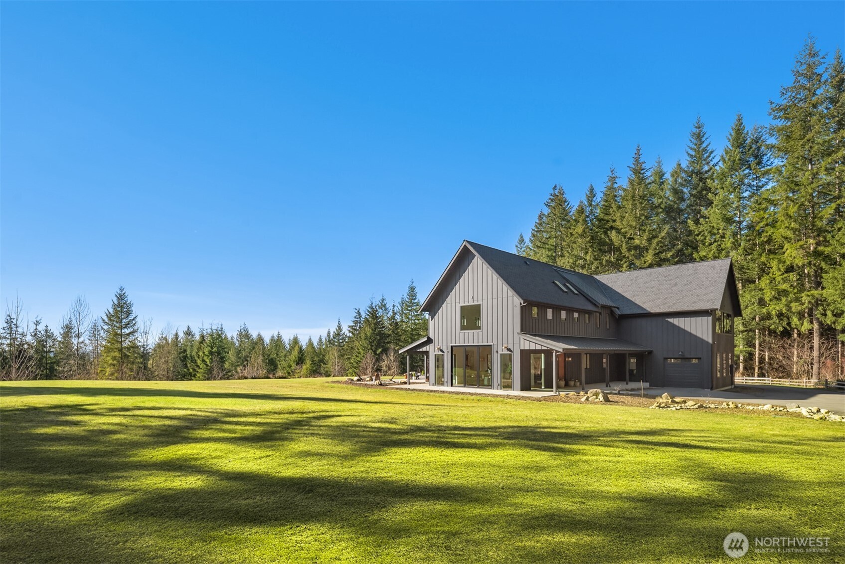 Nestled in the peaceful foothills of Carnation, this exceptional estate style property offers a rare blend of seclusion, space & pristine natural beauty. Set on 20+ acres of unparalleled privacy, this exquisite residence provides a tranquil retreat that feels worlds away while remaining conveniently close to amenities. Custom built & meticulously crafted in 2022, this immaculate residence boasts a sophisticated interior designed for effortless entertaining. The large great room offers soaring 32’ ceilings, striking vaulted fireplace & walls of glass that illuminate spacious, sundrenched living spaces. This breathtaking residence is loaded with every possible luxury amenity including a sumptuous main level primary suite, large butlers’ pantry, chic wine cellar & massive upper-level bonus rm w/built-in entertainment center. Huge bi-fold glass doors open to seamlessly blend indoor & outdoor living with covered patio areas, 2+acre level lawn & outdoor kitchen perfect for endless summer BBQs. The expansive property lends itself beautifully to a variety of future possibilities—use existing plans to build detached shop/garage, create a hobby farm, equestrian property or a custom luxury retreat with pickle ball courts. Expertly positioned to provide maximum seclusion down a private well-maintained road, yet within easy reach of downtown conveniences: 20 MINS TO MICROSOFT REDMOND | 30 MINS TO BELLEVUE | 40 MINS TO DT SEATTLE | 15 MINS TO DUVALL SAFEWAY | 15 MINS TO REDMOND RIDGE QFC.