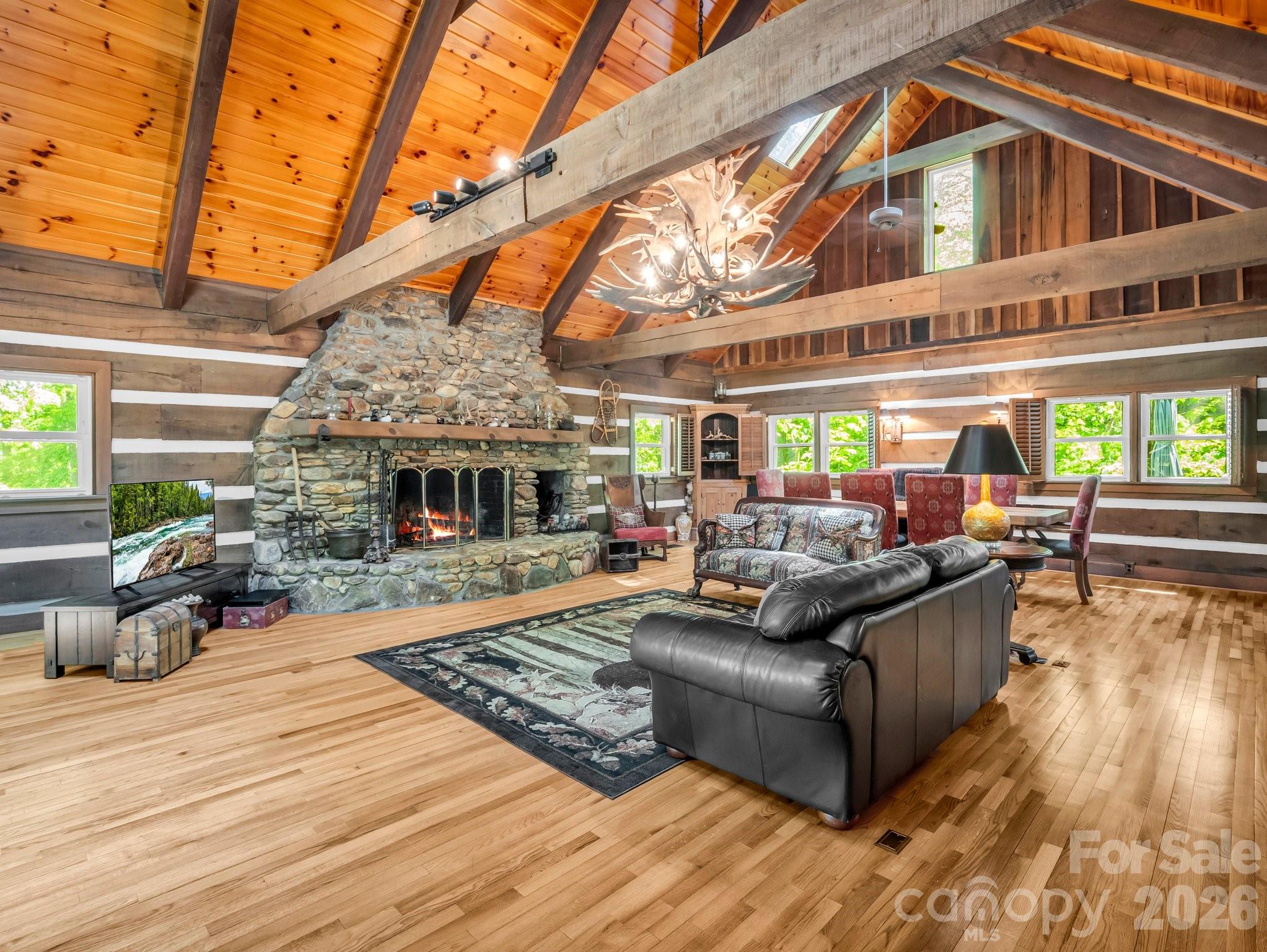 Welcome to one of Western North Carolina's most remarkable private mountain estates. Encompassing approximately 116 acres behind a private gated entrance, this extraordinary property combines luxury, recreation, equestrian amenities, self-sufficiency, and natural beauty in a setting designed to be enjoyed for generations. With 20 acres located outside of HOA restrictions, the property offers a rare combination of privacy, flexibility, and recreational opportunity. At the heart of the property sits a handcrafted dovetail log lodge constructed from timber harvested directly from the land itself. Surrounded by mountain views, streams, trails, and abundant wildlife, the home offers timeless craftsmanship and an unmistakable sense of place. Inside, soaring ceilings, exposed timber beams, expansive windows, and a grand stone fireplace create a warm yet impressive gathering space. The primary suite serves as a private retreat featuring its own fireplace along with separate his-and-her bathrooms.The estate is thoughtfully designed with a detached 647-square-foot guest apartment above the garage, complete with its own kitchen, full bath, bedroom area, and private entrance. Whether utilized for guests, extended stays, or additional accommodations, this flexible space adds significant value and versatility. Outdoor amenities are equally impressive. Enjoy two stocked ponds, multiple streams, established trails, hunting opportunities, and frequent sightings of deer, turkey, and other wildlife. The outdoor BBQ area overlooking the water creates an exceptional setting for entertaining, fishing, and enjoying the peaceful mountain surroundings. Two hunting stands are already in place for those seeking a true sporting retreat. Equestrian enthusiasts will appreciate the custom cedar barn featuring four stalls, tack room, loft with hay feeders, full bath, water, electricity, and adjacent pasture. A large cedar storage building provides additional space for equipment, tools, and recreational gear. Designed for year-round comfort and peace of mind, the property is equipped with generator systems serving the main lodge, guest apartment, and well house. Additional infrastructure includes two wells and a 290-gallon fuel storage tank. Even better, most furnishings, the tractor, UTV, and additional equipment convey, allowing the next owner to begin enjoying the property immediately. Properties offering this level of craftsmanship, acreage, infrastructure, recreation, and privacy are increasingly rare in Western North Carolina.