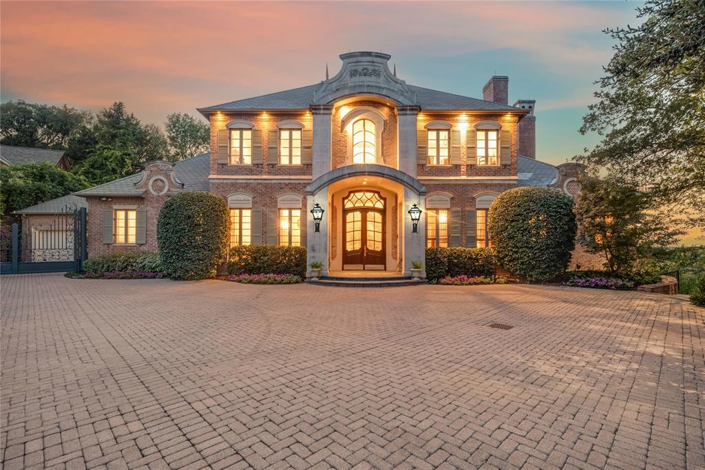 This masterpiece was conceived as a French château, shaped by European architectural influence and designed for lasting comfort. Many of the home’s architectural elements were sourced from Europe and installed first, with the structure designed around them, giving the residence a collected, timeless presence. Set on two wooded acres along the West Fork of the Trinity River, the property offers rare privacy while remaining equidistant to Downtown Dallas and Fort Worth. Winding trails lead to the water’s edge, while the rear of the home overlooks Lake Viridian. The residence spans 9,026 square feet across three levels, with an additional 835 square feet of flexible upper-level space, all served by an elevator. The main living areas are climate controlled by a geothermal system, with traditional HVAC serving the garage and flex space. The main level features a grand entry with Versailles-inspired flooring, sweeping iron staircase, and crystal chandelier. A central parlor opens through imported French château doors to the veranda and is anchored by a Louis XIV limestone fireplace. The formal dining room, wet bar, office with Regency-era fireplace and London post-office doors, chef’s kitchen with a separate catering kitchen, and a private primary suite with dual baths and custom closets complete the main floor. The pool level includes a full kitchen, wine cellar, game or studio space, laundry, and direct access to the resort-style terrace. The upper level offers three bedrooms, two baths, catwalk views, and a balcony suite overlooking the estate. A rare blend of European architecture, privacy, and location in the heart of North Texas.