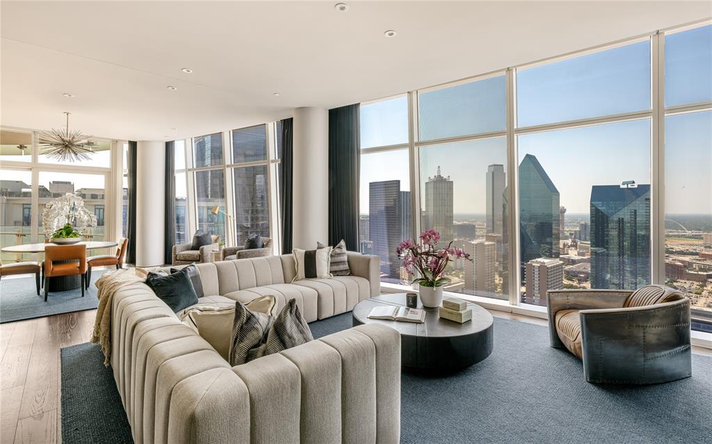 Perched high above the Dallas Arts District in the iconic Museum Tower, this impeccably reimagined 34th-floor residence delivers turnkey contemporary luxury framed by sweeping skyline views. Following an extensive, seven-figure architectural overhaul, every inch of the home showcases bespoke craftsmanship, refined materials, and state-of-the-art smart living.Wide-plank hardwood floors guide you into a luminous, open-concept living space anchored by a minimalist flameless linear fireplace and custom designer lighting. The chef’s kitchen is a masterclass in culinary design, equipped with Sub-Zero and Wolf appliances, dedicated wine preservation, custom integrated cabinetry, and an oversized waterfall island finished in Taj Mahal Quartzite, supported by an expansive walk-in pantry.The primary suite serves as a serene private retreat, featuring tailored built-in wardrobe systems and a spa-inspired bath complete with premium stonework and bespoke fixtures. A well-appointed guest suite offers complete privacy with a dedicated, fully updated bath. The residence is powered by a fully integrated Control4 smart-home automation system, seamlessly managing climate, audio, and architectural lighting scenes with a single touch.Complete with two dedicated garage spaces and private storage, residents enjoy Museum Tower’s world-class amenities: 24-7 concierge and valet, a resort-style pool and cabanas, wellness center, private dog park, and house car service.