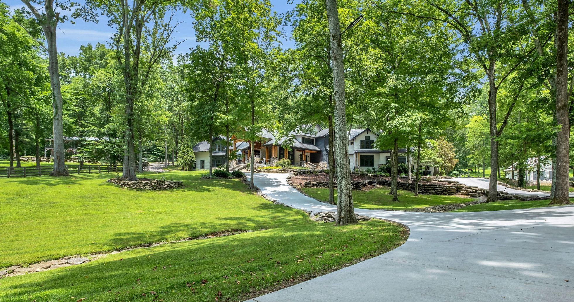 Tucked away on a peaceful, wooded ridge just beyond the coveted Westhaven community, is a true hidden gem—offering the privacy of Leipers Fork living with the convenience of Franklin just minutes away. This remarkable estate was not just built on the land—it was built from it. With native wood milled directly from the property and hand-selected stone woven into its design, this custom 5,748 sq ft home is a masterpiece of artisan craftsmanship and organic elegance. Inside, soaring windows bring in natural light and stunning forest views, while a grand stone fireplace, open-concept living spaces, and chef’s kitchen with high-end appliances create a warm and luxurious environment. The serene primary suite features spa-inspired finishes, with soaking tub, stone accent walls, full-body water shower therapy and luxury walk in closet. Step outside to a resort-like setting complete with a sparkling pool, waterfall, covered patio, and outdoor stone fireplace—ideal for relaxing or entertaining in total privacy. The 1,700 sq ft spacious pool house features a full kitchen, private bedroom and bath, lofted living space, and a large deck overlooking the beautiful pool—perfect for visitors or multi-generational living. The 3,500 sq ft barn takes the property to the next level, offering a unique venue for events, hobbies, or equestrian use. With custom bars, horse stalls, and open gathering areas, it’s ready to host unforgettable celebrations or support your lifestyle needs. A rare opportunity to own a property that blends natural beauty, exceptional craftsmanship, and refined living—just minutes from everything Franklin has to offer.