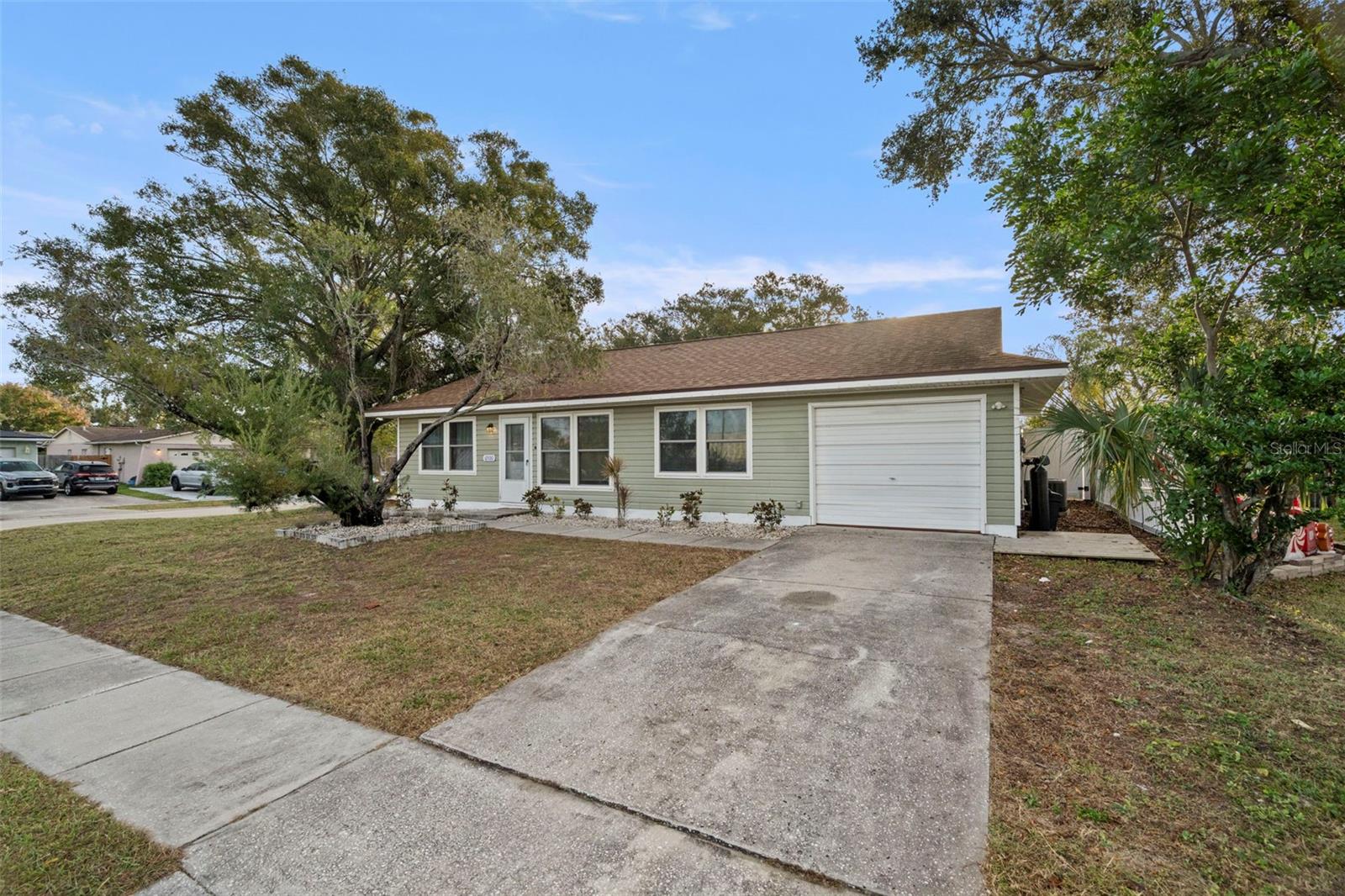 Super starter home! Spacious 2 Bedrooms, 2 Bathrooms and 1 Car Garage home on a LARGE corner lot! PAID Solar Panels 2019. Electric bills as low as $ 36./month! NO HOA. Beautiful cathedral and vaulted ceilings as you enter this split plan home. Modern amenities with a a cozy and comfortable feel! Newly renovated Kitchen with sleek countertops, contemporary cabinets and modern appliances. New Microwave 2025. Microwave & Stove are smart appliances- to control on your phone, if you like this feature! Hurricane-rated Windows in 2018, AC Heat Pump in 2021, Newer Vinyl Flooring in 2024, All newer fixtures in main bathroom for guests 2024, Newer Ceiling fans in Living Room and Both Bathrooms. New Shelving in Master Bedroom walk in closet 2024, New Smart Lock on Front Door 2025, New Interior Paneled Doors 2024. Matching Maytag Washer & Dryer in your separate Utility/Storage Room. Newer Roof 2021, New Siding 2022, New Vinyl Fencing 2025. Double French Doors with Built-in Shades- off of Dining Space to your Newer Covered Back patio to relax after work. Plenty of room in the back yard for your pets or entertaining, don't miss the Private Fire Pit with Chairs being left for the Buyers! Vinyl Fence has side gate to store those extra toys! SUPER location, close to Bryan Dairy to hop onto US19 goint to St Pete or North 275. Minutes to the Airport with the newer interstate nearby. Priced to sell! Being sold "as-is" for the sellers convenience. Please enjoy the Virtual Tour ~