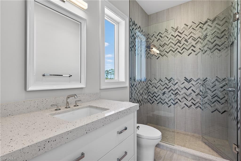 Full bathroom with vanity and a shower stall