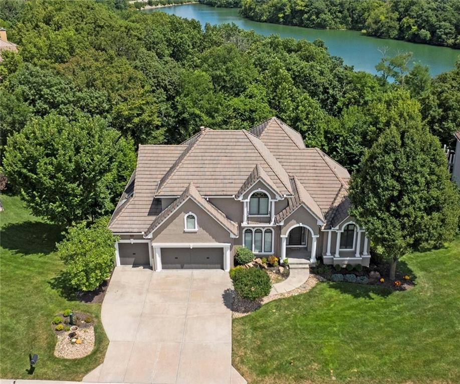 EXQUISITE, LAKEFRONT, Cul-de-sac Lot Estate in Riss Lake Reserve! Impeccably maintained! Inviting, tranquil waterfall feature welcomes you to the front door.  Soaring Vaulted Entry Ceilings, Picture-esc windows capturing the BEST seasonal Lake and Treed Views from every room! Stunning hardwood floors, trendy & fresh interior paint throughout! NEWLY remodeled Gourmet Kitchen! Crisp, Painted Cabinets, Hardware, Exotic Granite Counters and Island, NEW SS Appliances, Viking Gas Range, Viking Convection Microwave, GE Profile Double Oven, Bosch Dishwasher, Refrigerator, & Walk-in Pantry! Enjoy quiet shaded evenings, grill out, relax, and enjoy the VIEWS! Luxurious Primary Suite featuring see-through fire place, NEWLY REMODELED BATH, Heated, Imported Italian Porcelain Floors, Double Vanity, soft-close drawers, granite counters, Walk-in dual head shower, Jetted Tub, & CUSTOM DESIGNER CLOSET! Upper level features a huge loft with the outstanding LAKE VIEWS! 2nd Bdrm Suite, NEW carpet, walk-in closet & 2nd Washer & Dryer! Lower Levels is an ENTERTAINERS DREAM! Old World Bar with walk-in, 750 bottle Chilled Wine Cellar, Wetbar, custom cabinetry, Full Refrigerator, dishwasher, oven, microwave, and Second Deck! Additional office/study with incredible views! Workout room (or 5th bedroom), walk-in closet, and spa-like 4th Full bath! EV Charging Station in single bay garage, NEWer AC Units, Furnaces, & Tankless Hot Water Heater! Hardwired security & Control4 Entertainment System! Enjoy all of Riss Lakes Amenities! 3 swimming pools, Trails, Recreational Lake, Tennis Courts, Playground, and Maintenance Provided! Monthly $235 HOA for covers lawncare maintenance, seasonal start/winterization or irrigation, and snow removal! , and great access to Parkville’s finest local shops, restaurants, parks, walking/biking trails… This is luxury lifestyle living at its finest! LOVE WHERE YOU LIVE!