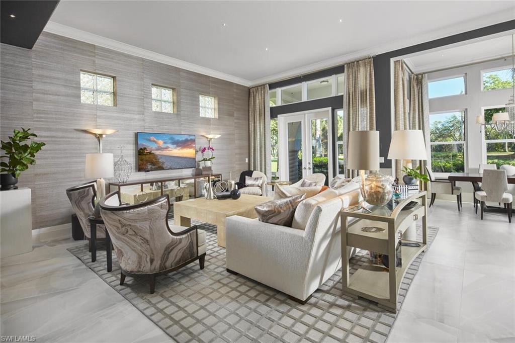 This exquisitely curated 4-bedroom, 4.5-bathroom completely remodeled home in the heart of The Colony offers a masterclass in coastal elegance and architectural sophistication. From the moment you enter, the home captivates with an airy, open-concept design defined by soaring 14'ceilings, floor-to-ceiling windows, and refined finishes that invite the lush Florida landscape inside.Designed for those who refuse to compromise on style or substance, this residence isn't just a home, it's a sanctuary where every designer detail has already been perfected.The grand living area serves as the centerpiece of the home, featuring designer wall treatments and a seamless flow into the dining space, perfect for hosting intimate dinners or large-scale gatherings. Natural light pours through expansive glass doors, highlighting the large scale tile flooring that runs throughout the main living areas.The dream kitchen is a culinary masterpiece, centered around a massive waterfall island and framed by a majestic arched entryway. High-end features include custom white shaker cabinetry with integrated lighting, premium stainless steel appliances and a professional-grade vent hood and a picturesque arched window overlooking the tropical grounds.The primary wing is a private retreat defined by understated elegance. Wake up to serene views through expansive windows, or step directly onto the master terrace to enjoy the morning breeze. The spa-like master bath is a sanctuary of its own, featuring dual floating vanities with sleek hardware, deep soaking tub and a massive frameless glass rain shower and bespoke wall coverings and striking fixtures.Step outside into your abundant private veranda. The outdoor space features a custom stone waterfall fountain that cascades into a heated spa and pool. Overlooking a serene lake with a central fountain, the primary terrace and patio areas provide the perfect backdrop for evening cocktails and sunset views.Exceptional Details include architectural arches and high ceilings that enhance the sense of volume.Lush tropical landscaping surrounding the property for maximum privacy, private elevator, new hurricane impact windows and doors and new roof in 2025.Why wait months for renovation when perfection is ready right now? This captivating estate is offered fully realized and move-in ready, allowing you to bypass the process and proceed straight to the lifestyle you’ve earned. Living at The Colony includes private membership to The Bay Club,formal and informal dining and events. Access to a PRIVATE BEACH PARK, a huge tennis program, canoeing/kayaking, sailing club, bocce &pickleball, the list goes on! Elective private golf options. The Colony is a quick jaunt to the airport and just a mile and a half to great dining and shopping.