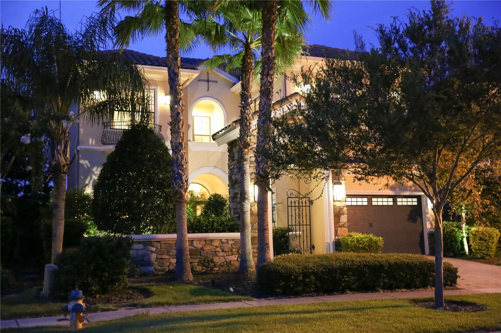 From the moment you step through the front gate and into the private courtyard , you will understand why this lovely villa is named Villa of Joy.  Luxury living awaits you. This home is one of the most delightful and contemporary homes in this exclusive Community. While each room is impeccably designed, the villa maintains an environment of tranquility and relaxation. The home features 5 spacious bedrooms , all with ensuite bathrooms. The master bedroom , and two further bedrooms are located upstairs, while two bedrooms are downstairs.  There are three unique living areas , perfect for families that need a lot of space.The formal living room features a built in fireplace, cathedral ceilings and modern styling surrounded with natural light from the wall of french doors.  The gourmet kitchen, fully fitted with stainless steel appliances has two dining areas.  The outdoor amenities will not disappoint.  The pool area is paved , and boasts a summer kitchen with bbq, sink and refrigerator .  From the rear of the property, either from the pool deck or viewing from the large tiled balconies above, you can enjoy a panoramic view of natural woodland and the golf course.  Reunion Resort offers its own array of entertainment, amenities and restaurants and is also conveniently located  minutes drive from the many other famous Orlando attractions such as  Disney, Universal Studios and Sea World.