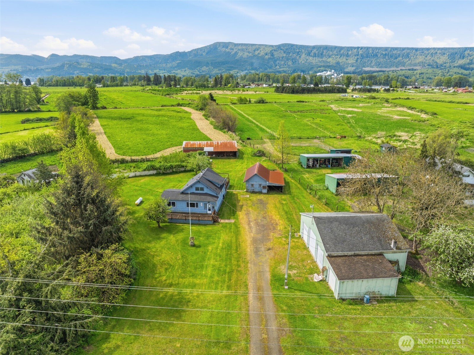 A 1900's traditional farmhouse offers a unique blend of historical charm, agricultural utility and peaceful living with waterfront along Welcome Slough. The residence features a sturdy, classic home w/large living, spacious kitchen w/woodburning stove, modern appliances, eating peninsula & breakfast nook. High ceilings, main floor bedroom & welcoming entry way will surprise you.  With nearly 5 acres of flat, fertile soil, the property transitions from working fenced pasture to garden area, large, beautiful front yard adding curb appeal and a huge back deck for entertaining! The 174' along N Welcome Slough is ideal for EZ kayaking, paddle-boarding, canoeing or bring in your sailing, fishing or large boat as the deep-water accommodates these vessels. Dock is in need of love, but the bones are there! The shop is efficiently situated along the edge of the driveway and built to store the tractor, mower, tools & hobby goods with RV parking inside or alongside.  The barn out back will provide cover for the critters or additional storage for the tractor & implements. Additional outbuilding could use some vision and your toolbelt but provides another area of storage or perhaps a greenhouse, garden shed, playhouse - or really overhaul it into potential guest space! Fenced versatile pen for chickens, goats, dogs, you decide. This property represents a rare time capsule lifestyle and quiet rhythm that comes with being surrounded by the mighty Columbia River at peaceful Puget Island.
