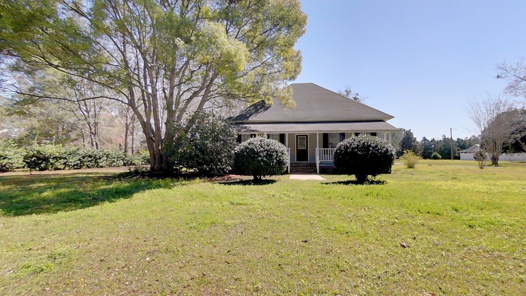 Charming Farmhouse – Spacious and Close to City Conveniences! Discover the perfect blend of country charm and modern convenience in this spacious home nestled on just under an acre. Boasting 2,062 square feet, this home offers ample room to spread out while still maintaining the cozy farmhouse feel. Located in a peaceful setting, yet minutes from city conveniences, this home is ideal for those who want the best of both worlds. Step onto the inviting covered front porch, perfect for rocking chairs and evening relaxation. Inside, you'll find high ceilings and an abundance of natural light that enhances the spaciousness of every room. The large eat-in kitchen, featuring plenty of counter space, a pantry area, and appliances—plus, there's still enough room to add an island! The formal dining room is perfect for hosting large gatherings. A separate living room, accessed through refined glass French doors, at the front of the home provides a welcoming space for entertainment and comfortably accommodates oversized furniture. The split-bedroom floor plan ensures privacy, with a very generous sized primary suite that floods with natural light and includes an oversized walk-in closet, a private bath with a step-in shower, vanity sink, and private toilet area. The guest bedrooms are oversized with high ceilings and ample closet space. A Jack-and-Jill bath connects two of the guest rooms, offering convenience, while a half bath off the wide hallway is perfect for guests. Additional features include a septic tank, private well, large laundry/mudroom, ample storage space throughout enhancing the home's flow and functionality. Outside, you'll find a cozy courtyard area with natural vegetation for privacy, plus a storage shed with power and a detached carport with plenty of backyard space for future expansion. A ramp-accessible back deck provides another great outdoor space to enjoy. With its recently painted interior, and endless potential for personalization, this home is move-in ready while still offering room for your unique touch. Whether you're drawn to its classic farmhouse character, modern conveniences, or unbeatable location, this home is sure to capture your heart.  Don't miss out on this charming country escape!