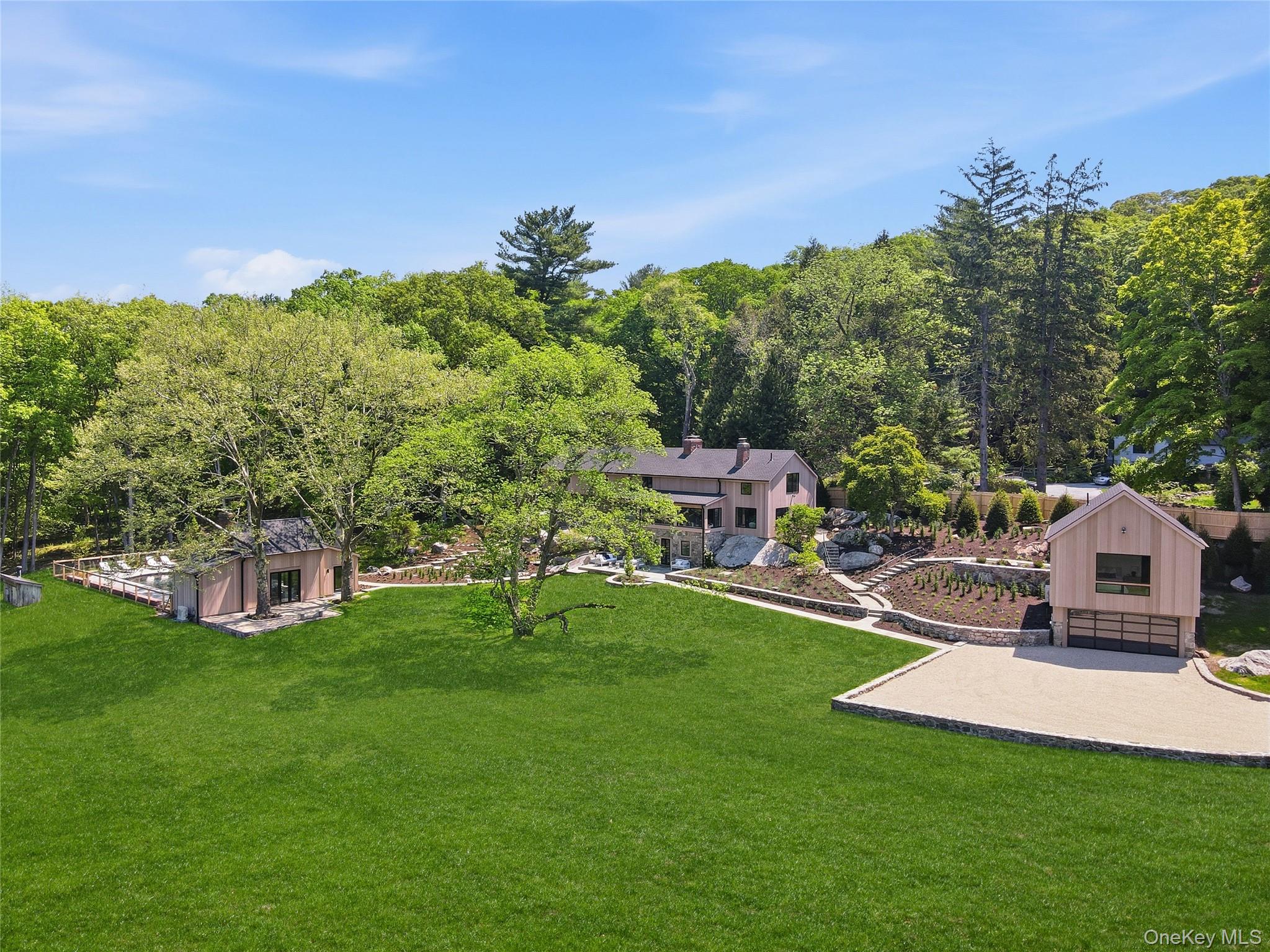 Behind private gates, nearly six acres of bucolic countryside unfold around a spring-fed lake — a setting that feels worlds away, yet sits just one hour from Manhattan.Gut-renovated to the studs and reimagined from the ground up, this Pound Ridge estate blends Mid-Century Modern design with original stone construction and hand-hewn beams — a rare marriage of architectural integrity and contemporary refinement. The result is a home that feels both timeless and entirely of the moment.The main residence offers four bedrooms and has sweeping water views that define the property. A detached guest studio with two-car garage provides flexible accommodation for visitors or staff, while the heated gunite pool and pool house — complete with full bath, wet bar, and huge fireplace — create an effortless setting for both quiet evenings and elevated entertaining. An additional detached two car garage rounds out the offering.Outside, the grounds have been as thoughtfully curated as the interiors: new landscaping, artisan stonework, full irrigation system, patios, and mature tree work frame the lake and connect seamlessly to the Pound Ridge Land Conservancy — a permanent buffer that ensures the privacy and natural beauty of this property endure.Truly turnkey. Completely one-of-a-kind.