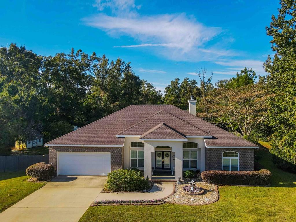 HUGE PRICE IMPROVEMENT!!  MOTIVATED SELLER!!If you are looking for a quiet area and a stately home with lots of amenities, THIS IS IT!!  This home features SOLAR POWER WITH TESLA BATTERY BACKUP!!!  It has almost 3 ACRES WITH A FIGURE 8 WOODED WALKING TRAC and 6' privacy fence.  There is a concrete parking pad with hook up for your RV, and a pad for a fire pit, and a 5X7 garden shed and a very cute10x20 playhouse building too!!  As an extra plus there is a bearing lemon tree!  There's a solar powered fountain out front too!  The 12x20 deck features a very nice 12x20 SUNSETTER AWNING as you come outside from the sunroom! Lawn irrigation. This home features an interior/exterior camera security system, and pet door from porch.  Special features inside are:  reverse osmosis tankless water heater, a built-in Wavary murphy bed, breakfast nook, split floor plan, large pantry, new refrigerator/freezer, jacuzzi tub for 2, 2 built-in wall ironing boards, nest thermostat, and spacious closets.  This home is very economical to heat and cool because of solar! There's so much to describe, you need to  call your agent for an appointment to see!!