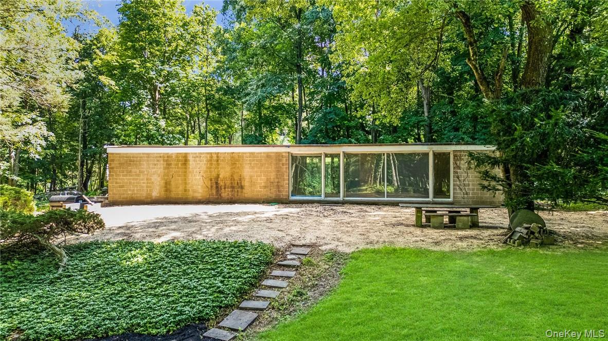 "All architecture is shelter, all great architecture is the design of space that contains, cuddles, exalts, or stimulates the persons in that space." Philip Johnson. Philip Johnson's first commissioned home. Commissioned before the Glass House. The Booth house is a rare  architectual gem, waiting for a discerning buyer to restore it to its original glory and timeless elegance. This 1946 Signature Mid- Century Modern is tucked away on 1.6 acres with 2 additional buildable lots totaling 2.59 acres . All 3 lots together equalling 4.28 acres. Spectacular hilltop setting abutting a 36 acre nature preserve & close to Bedford Village.  Steps away from the modern home you will find a large studio/ guest space with high ceilings & lots of light. This additional building can be restored for many purposes. Rarely does an opportunity arise to own a residence of this caliber with such architectual history and significance. If a Philip Johnson design isn't quite your vision, this property offers the ideal canvas for a discerning buyer to reimagine and craft their own home -tailored perfectly to your style and taste.