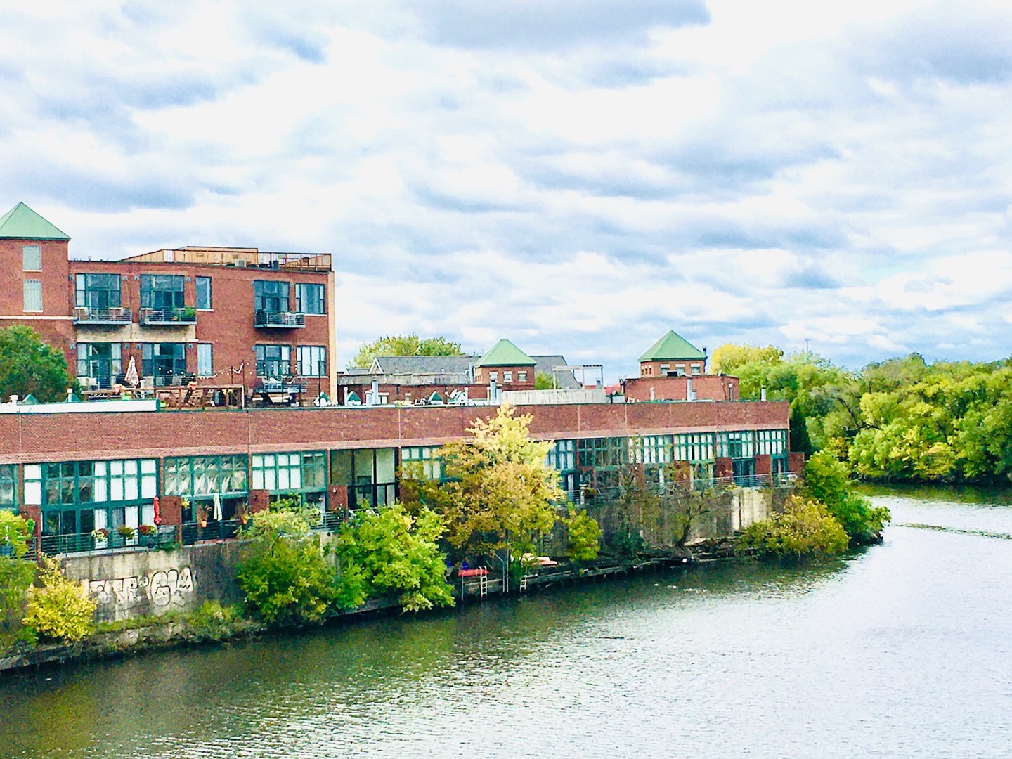 SEE MATTERPORT 3D TOUR & VIRTUAL TOUR. Largest unit in the building - 2 separate units were combined by the developer to make a spacious 1800 square foot 3 bed 2 bath penthouse unit that overlooks the Chicago River. This lofted unit has a great split open floor plan, updated kitchen, high ceilings, exposed brick, hardwood floor and huge windows throughout.  There is a private deck off the living room and a 2nd deck off the primary bedroom, along with a huge common roof deck for the residents' enjoyment.  This is an elevator building and comes with one heated garage parking space (#32).  This gated community has launch access for kayaks into the river.  Perfectly located between Logan Square, Roscoe Village and West Lakeview, this home has easy access to the highway. The Diversey bus will quickly take you to either the Blue Line West or the Brown Line east  Pet friendly and much more!