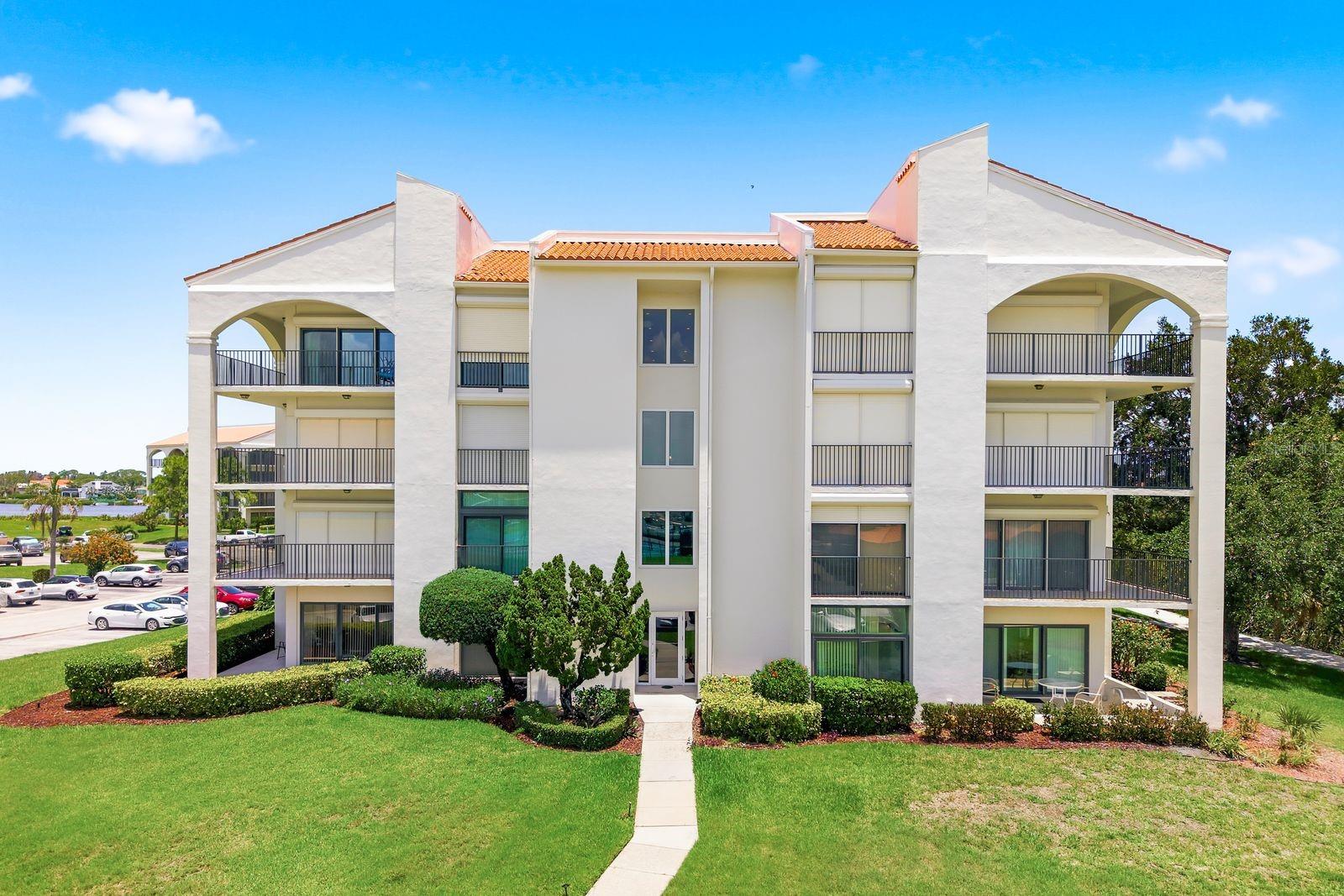 Welcome to resort-style waterfront living at Mariner Village at Tarpon Cove, a gated community in the heart of Tarpon Springs offering exceptional amenities and a true Florida coastal lifestyle. This beautifully updated 3-bedroom, 2-bathroom condo features 1,666 square feet of spacious living with an open floor plan designed for both comfort and entertaining. Upgrades include hurricane impact windows and doors, electric hurricane shutters, and the convenience of a building elevator.  Step inside through the welcoming foyer entry complete with a convenient coat closet and immediately notice the beautiful hickory wood flooring and abundance of natural light streaming through the windows. The updated kitchen is a standout with Quartz countertops, stainless steel appliances, a breakfast bar, and seamless flow into the main living and dining areas. The bright and airy living space opens to a nicely sized balcony with peaceful nature views, creating the perfect place to relax and enjoy the coastal surroundings. The split-bedroom layout provides added privacy for owners and guests alike. The spacious primary suite features a private en suite bathroom complete with a dual-sink vanity, private water closet, and a walk-in closet with custom shelving. Two additional nicely sized bedrooms each offer balcony access and tranquil nature views, creating inviting spaces for guests, family, or a home office. The second bathroom includes a convenient tub/shower combo. Residents of Mariner Village enjoy an impressive list of resort-style amenities, including a clubhouse, fitness center, sauna, heated pool, tennis and pickleball courts, walking paths, and kayak access. The monthly condo fee includes cable, internet, water, trash, 24-hour gate, and more, providing both convenience and peace of mind. Ideally located just a short drive from Sunset Beach, Honeymoon Island State Park, the charming downtown areas of Palm Harbor and Dunedin, and the famous Tarpon Springs Sponge Docks, this location also places you near Innisbrook Resort golfing, dining, shopping, and endless coastal attractions. Experience maintenance-free waterfront living in one of the area’s most desirable gated communities. Schedule your showing today!