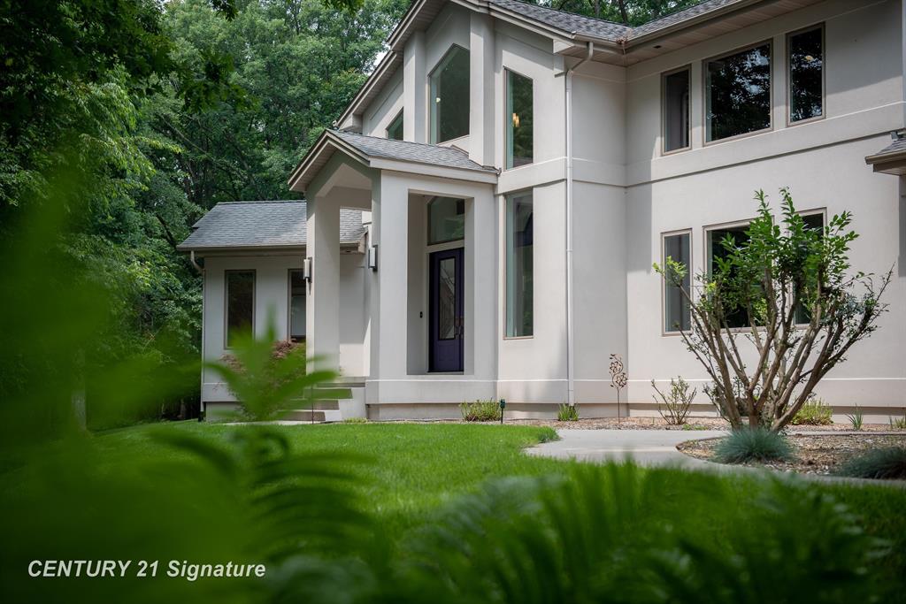 A true architectural statement, this Bill Phillips"“designed estate stands among the most exceptional homes currently on the market. Set on 5.54 private, wooded acres, the residence offers four bedrooms and 4.5 baths, blending refined elegance with thoughtful, high-end functionality throughout. The custom main-floor primary suite is a private retreat, exuding understated luxury. Highlights include a personal fireplace, private deck, and a spa-inspired bath complete with its own fireplace, soaking tub, expansive shower, and exceptional closet space- with bespoke shoe storage. Every detail has been curated to support a sophisticated, yet livable lifestyle. Designed with both entertaining and everyday comfort in mind, the main living areas overlook the serene acreage beyond. Extra-thick Canadian maple flooring flows throughout the home, providing a warm, timeless foundation that beautifully supports transitional d©cor. A striking three-way gas or wood-burning fireplace anchors the space, while floor-to-ceiling windows flood the interior with natural light. The gourmet kitchen is nothing short of stunning, featuring Dacor professional-grade appliances, expansive granite countertops and backsplash, a designer hood vent, generous pantry space, and a custom cookbook cabinet. Dining options are equally impressive, offering seamless transitions from the statement island to a quiet eat-in area, and on to the formal dining room. A butler's pantry with upscale wine refrigeration, abundant storage, and refined lighting provides a second serving area ideal for entertaining. The finished lower level extends the home's versatility, offering a fourth bedroom with private access to a full bath, a dedicated fitness room, workshop, walk-out access to the back patio, and tremendous storage. From construction quality to the strategic sourcing of materials, this home reflects a level of professional design and craftsmanship that is both evident and enduring. The oversized three-car garage easily accommodates more than vehicles, while p