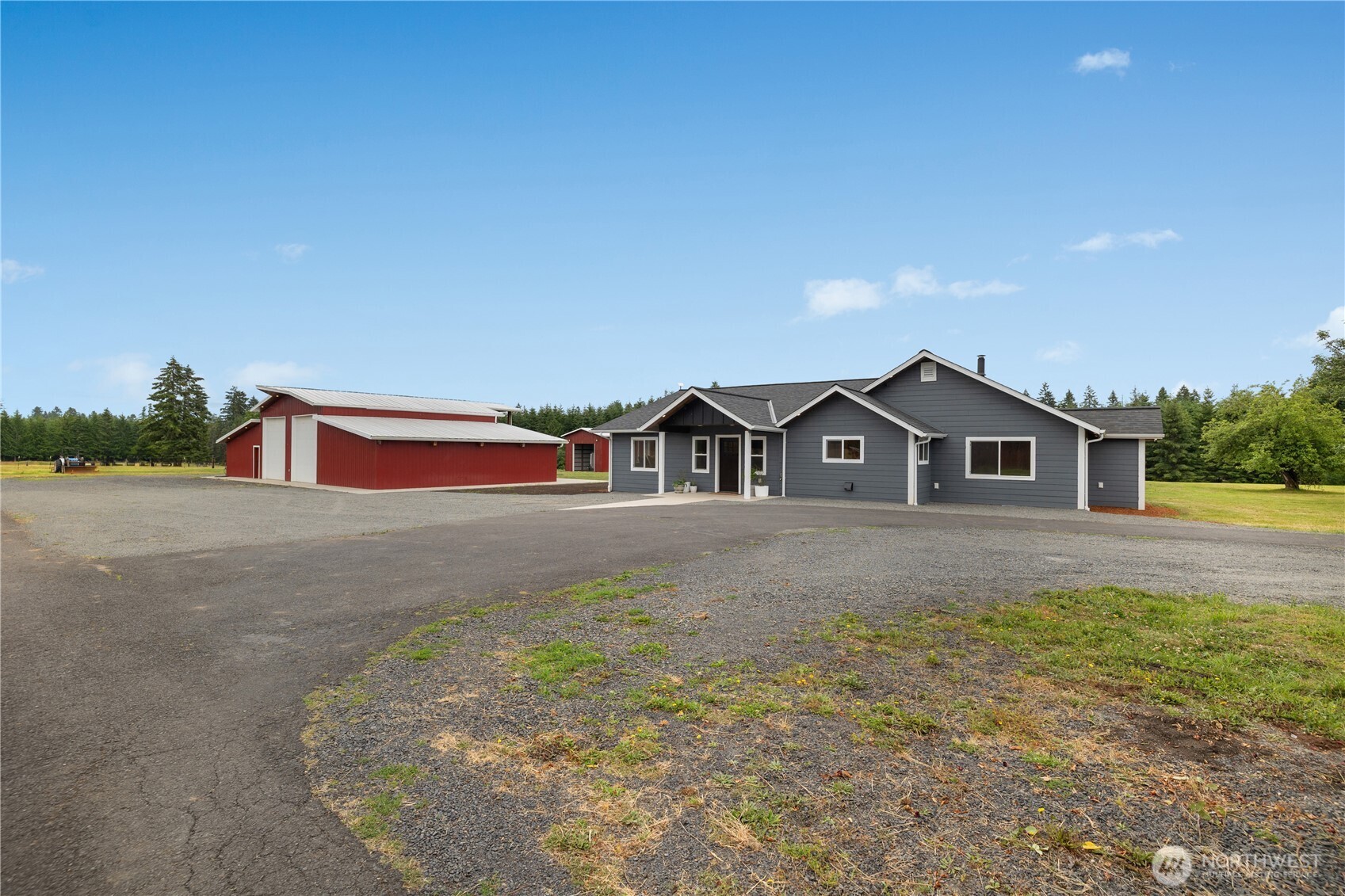Exceptional craftsmanship and quality define this beautifully remodeled custom home on 11.49 private acres surrounded by tree farms. Every detail has been thoughtfully designed from the hardwood floors, solid wood doors, wrapped windows, custom lighting details and heated tile floors to the spray foam insulation throughout the entire home for incredible energy efficiency and a quiet living experience. The stunning kitchen features honed granite countertops, custom brick backsplash, farmhouse sink, built-in appliances, and a Sub-Zero refrigerator. The vaulted great room offers a wood stove with brick hearth and a built-in coffee bar all with custom lighting. The luxurious primary suite includes patio access and a spa-inspired bath with heated tile floors, dual vanity with under cabinet lighting and an oversized walk-in shower with lighted shower niches. The incredible 40' x 77' heated and air-conditioned shop is a dream! Shop features epoxy floors, exposed wood beams, four overhead doors including two 14' RV doors, a large sink and additional bathroom plus a finished 400-square-foot loft with separate access. The loft includes plumbing for kitchenette, a bedroom, washer and dryer, mini-split, and bathroom—ideal for guests, a home office, or additional living space. Outside, you'll find Trex decking, a covered wood porch, two cross-fenced pastures, a chicken coop and a 24' x 40' barn with power and water. A truly one-of-a-kind property offering unmatched quality and privacy.