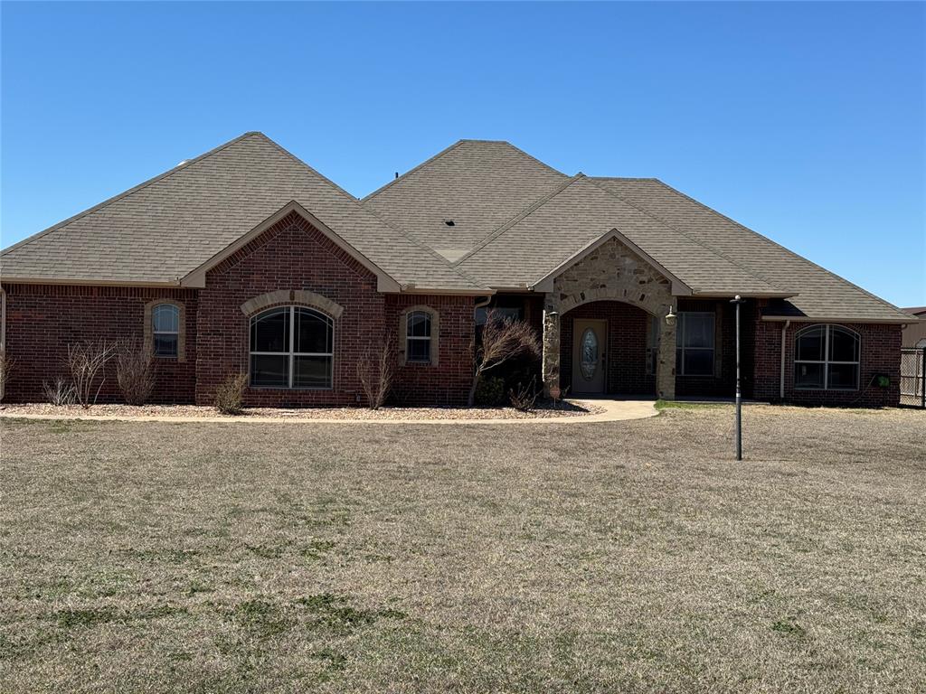 What a find! A home with a workshop on 1.1 acres is ready for a new family. A large front porch with a rock archway welcomes you home. Entering the home there is a study or a home office. Large open living room with a gas log fireplace. Dining room and kitchen are open to the living room. Kitchen has alder wood, stained cabinets, an island, granite counters, gas cooktop and an electric built in oven. Double ceiling fan and light, pendant lights over the sink and under counter lighting. Large pantry, utility room has a folding counter, upper storage and 2 storage closets. Then you can access the master closet from the utility room. WOW what a closet!!! Lots of hanging space and shelves, upper hanging for your seasonal wardrobe. At the back of the closet is the safe room, solid concrete walls, shelving, a gun rack and most important lots of room for your family. Master bathroom has double sinks, linin storage, alder wood, stained cabinets and a curb less walk-in tile shower with a door. Double doors to the master bedroom with box ceiling and crown molding. Bedroom 2 & 3 both have box ceilings and ceiling fans with lights. Hall has a closet on each side of the hall bathroom. Bathroom has a tub/shower combo with a recessed tile insert and granite counter vanity. Covered back patio with 3 brick arches and a propane stub out for your grill. What a yard, lots of room for a pool or just lots of room to run! There are some fruit trees at the back fence. Skid mounted storage shed with double doors. The workshop has a lot of cabinets and a toilet room. The front opens to a large open room to work in. All cabinets and the workbench stay. A must see to appreciate all the possibilities. Rural Water, OG&E electric, Aerobic system and propane. Chain link fencing at the front and the rest is fenced with a wood and metal post fence. Home was built to be wheelchair accessible, wide doors and low carpet.