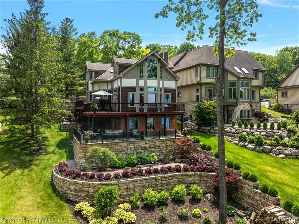 Experience luxurious lakefront living on All-Sports White Lake. From breathtaking year-round sunsets to impeccable custom finishes, every detail has been thoughtfully designed and meticulously maintained. Grand two-story foyer featuring elegant travertine flooring setting the tone for the craftsmanship found throughout. The chef’s kitchen is a culinary dream, equipped w/ premium Viking appliances including a 6-burner range, double ovens, built-in refrigerator, and commercial-grade hood and custom cabinetry. Entertain in the formal dining room or relax in the inviting living room w/ panoramic lake views, a cozy FP, and French doors leading to the expansive wraparound composite deck offers the ultimate setting for outdoor entertaining. Main level office/optional bedroom, plus a custom travertine bath w/ new fixtures, copper sink, and rich travertine countertops, add flexibility and sophistication. First floor laundry room features travertine flooring, Chabert Duvall cabinetry and new LG front-load washer/dryer combo. Upstairs, European white oak flooring leads you to a truly remarkable primary master suite with custom fir beams, cathedral ceilings, built-in custom cabinets, bay window, dual custom WIC and limestone trimmed gas FP. The luxurious spa-style ensuite boasts gorgeous cathedral ceilings, double vanity, heated floors, Italian porcelain tile, curb-less walk-in shower, Brizo fixtures, freestanding tub, and Toto fixtures. Two spacious bedrooms and fully remodeled bathroom complete this level. Finished walkout LL features a full kitchen, guest bedroom, remodeled full bath, comfortable family room opening to show stopping multi-level Pennsylvania bluestone patio w/ custom spiral staircase. Professionally landscaped w/over $500,000 in custom retaining walls, terraced gardens, mature plantings, and lighting making the outdoor space as stunning as the interior.  Additional highlights include newer HVAC, freshly stained cedar shake siding, and updated exterior paint.