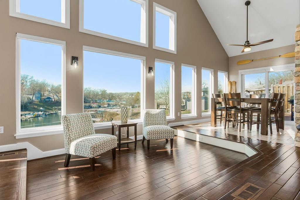 Experience lake living at its finest in this truly majestic Lake Lotawana home—perfectly positioned in the highly sought-after Mallard Bay. Enjoy sweeping views of the entire cove and main channel from nearly every room. Inside, a grand living area welcomes you with 16’ ceilings and expansive windows that frame the stunning lakefront scenery. The open-concept design centers around a beautifully appointed kitchen featuring quality cabinetry, granite countertops, and a generous island—perfect for hosting holiday gatherings or entertaining after a full day on the water.  A striking see-through fireplace connects the living room and the primary suite, where you’ll find a spacious bath with double vanities, two person jacuzzi tub and a generous walk-in closet. The main level also includes two additional bedrooms, laundry, a flexible office or formal dining space and an oversized garage. The impressive lower-level walkout provides an entire second living area with a full kitchen, laundry, large bedroom, tile flooring, and another fireplace, plus access to a second full sized garage—ideal for guests or extended stays making this feel like a private retreat of its own. The other half of the lower level features an expansive entertainment room with a full bar and theater, large bedroom with access to a lakeside patio, an ensuite bath and walk-in closet. Outside, two composite decks and two connecting lakeside patios offer multiple spots to unwind and enjoy unforgettable sunsets. Just steps from the lake an additional patio leads to the covered shared-well dock equipped with a powered boat lift. This quality-built home also features durable 2x6 exterior framing. Storage is plentiful, and parking is available for up to ten vehicles. Take your golf cart just a few miles to the park, tennis courts, locally owned restaurants, boutique shops, and coffee shop. Lake Lotawana offers a vibrant lifestyle — fishing tournaments, skiing, sailing, community events, and more.