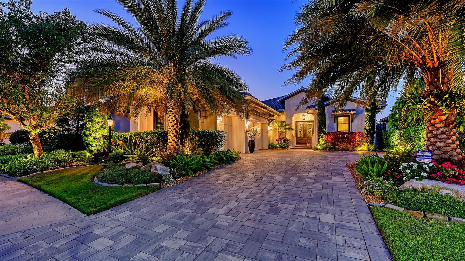 Located in the highly sought-after Matera section of The Lake Club, this green-certified Wetherington home, built in 2021, offers luxurious upgrades and custom details throughout. Enter through double handcrafted iron doors into an open, airy floor plan with designer chandeliers, plantation shutters, unique square LED recessed lighting, tall crown molding and porcelain tile floors throughout. The great room features a cypress wood beam coffered ceiling and a shiplap feature wall. Double doors off the great room open into the home office/den. 
Four panels of sliding glass doors pocket so a whole wall of the great room opens up to the expansive travertine lanai with a heated saltwater pool and spa. Enjoy alfresco dining by the outdoor kitchen, its stainless steel grill and beverage cooler. The chef’s kitchen includes GE Monogram appliances, quartz countertops, white cabinetry, mosaic glass tile backsplashes, a hidden pantry room, and a large central island/breakfast bar. The adjacent dining room overlooks the lanai and lush landscaping. The primary suite is a private retreat with a double-tray ceiling and large windows. The spa-like primary bath includes a walk-in shower, freestanding tub, quartz counters, and shiplap accents. The two guest bedrooms with ensuite baths and custom closets are both positioned to provide comfort and privacy. The large laundry room offers ample counter space, and the Wetherington signature "Florida Basement" offers extra storage. The 3-car side-loading garage features epoxy flooring. In the Matera section of The Lake Club, the HOA maintains the grounds, irrigation, and your pool, so you can enjoy carefree living. The Lake Club offers resort-style amenities, including a grand clubhouse, restaurant, pool, tennis, fitness center, walking trails, and interlinking lakes for kayaking and fishing.