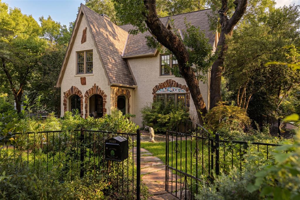 Located in the heart of Kessler Park, this extraordinarily rare historic Tudor is an architectural jewel rich in story and soul. Built in 1935, the home was once owned by the legendary Red Bryan—his original barbecue pit still resting in the backyard as a nod to the home’s colorful past. Since 2015, the current stewards have thoughtfully expanded and renovated the home, achieving the rare balance of seamlessly blending old and new while preserving every original architectural detail. Inside, you’re immediately enveloped in warmth and character only a lovingly preserved historic home can offer. Every detail has been carefully considered and honored, including the original mosaic lintel panel, echoed inside as the fireplace hearth and kitchen backsplash. Beautiful formal spaces flow into a generous kitchen with a La Canche range and a dreamy banquette overlooking the gardens. Plaster walls, romantic leaded glass windows, original ironwork, and custom English and Parisian wallpaper and drapery create a layered, soulful environment reminiscent of a French countryside estate. Offering 4,665 square feet across four stories, the home includes five bedrooms and a rarely seen full basement with a kitchen, laundry, bath, flexible living space, and abundant storage. The floor plan is ideal for both entertaining and everyday living—maximizing function without compromising design. Outside, rolling hills, mature trees, and lush gardens create a storybook setting straight out of an English fairytale. A truly special opportunity to own one of the most architecturally significant homes in Kessler Park.