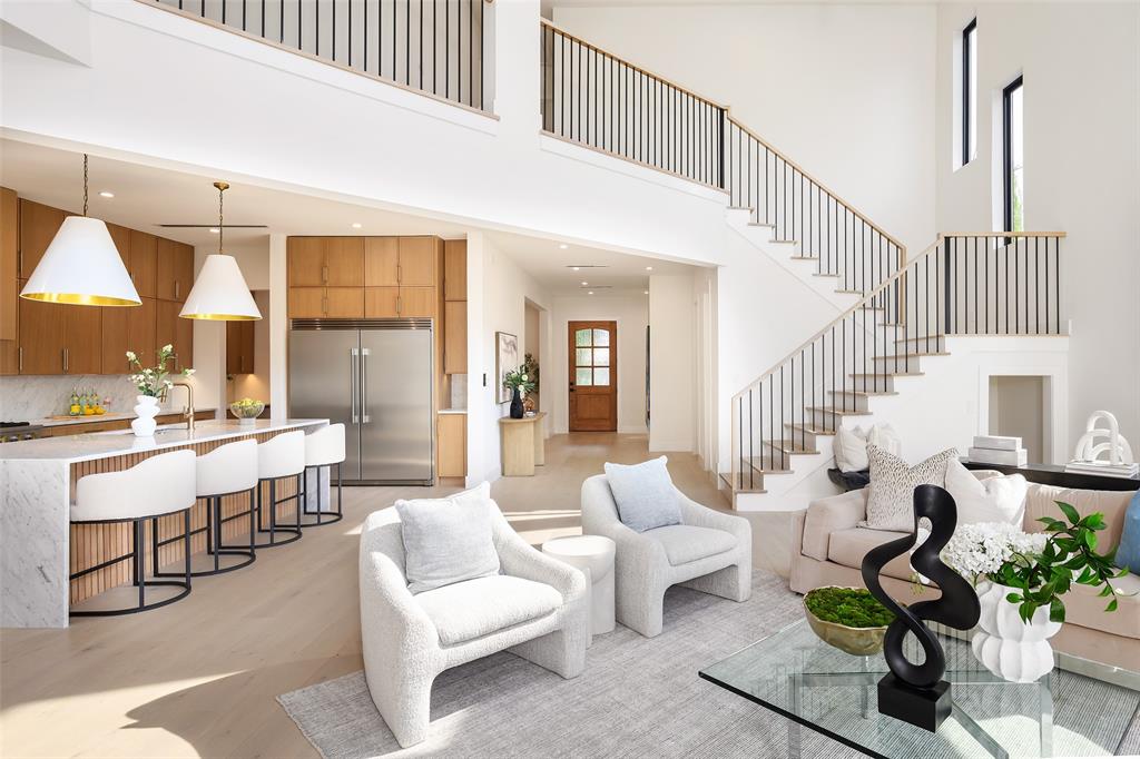 Giving California vibes, this 2008 home was reimagined with a striking white stucco façade, all new black-framed windows, with a welcoming covered entry with classic columns and a balcony above. Inside, soaring ceilings and walls of windows flood the home with natural light. The spacious living room features a sleek marble-accented fireplace and is open to the gorgeous new kitchen with custom white oak cabinets, GE Monogram appliances as well as a butler's and walk-in pantry. This home has two primary suite bedroom options, one downstairs and one up. Both primary suites have dual vanities, a freestanding soaking tub, and an expansive walk-in shower with frameless glass enclosure. Also downstairs, you'll find an office with a full bath, formal dining room and laundry room - complete with a pet washing station! Every detail is elevated with contemporary fixtures and sophisticated finishes. Upstairs the wide plank white oak floors and tall ceilings continue, with a large bonus space that's open to the downstairs, two additional secondary bedrooms, and the second primary suite, this one with a balcony and a marble tile bathroom. It's not just the interior that's had a facelift, but between the walls as well. The entire home is encapsulated in spray foam insulation, new electrical, new windows, new HVAC, PVC plumbing, and a tankless water heater to name a few. A rear electric gated entry opens to the backyard, with a detached two car garage and an air conditioned guest quarters above complete with a full bath. Walkable to Lower Greenville's retail and restaurants.