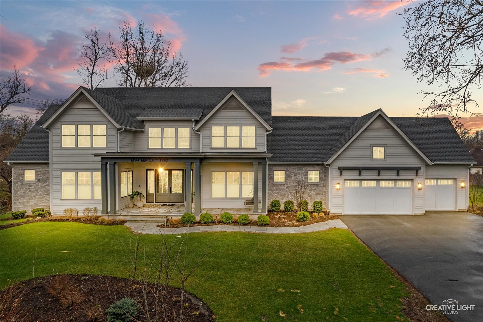 This exceptional custom home, built in 2022, offers a rare blend of refined design, elevated finishes, and an unbeatable location. From the moment you arrive and step onto the covered front porch, the craftsmanship and thoughtful detail are immediately apparent. The foyer opens to a breathtaking great room where soaring two-story ceilings, a statement fireplace, custom built-ins, plumbed for an elevator, and motorized blinds create a space that is both dramatic and inviting, all bathed in natural light. Rich hardwood flooring carries you into the heart of the home-a stunning chef's kitchen designed for both beauty and function. A striking quartz island anchors the space, complemented by custom cabinetry featuring specialized storage for every need, from utensils and spices to cookware and baking essentials. Elegant blue tile accents provide a sophisticated backdrop to the Cafe stainless steel appliances. The adjacent breakfast room is a showpiece of its own, surrounded by windows on three sides and highlighted by a beautifully detailed wood ceiling, while a spacious walk-in pantry ensures everything has its place. The main level primary suite is a true retreat, showcasing a designer ceiling with wood beams, a custom walk-in closet, and a spa-inspired bath complete with dual vanities, a tiled shower with seating, heated tile floors, and a private water closet with a smart toilet with bidet. This level also offers a second bedroom, a versatile den, a formal dining room, a full bath, and an exceptionally well-designed utility room with abundant storage for everyday living. The four-season room is not to be missed, featuring a wood ceiling and heated bluestone floors, creating a cozy yet sophisticated space to enjoy year-round. Upstairs, a spacious loft overlooks the great room and is flanked by two generously sized bedrooms. The thoughtfully designed full bath includes a beautifully tiled tub and shower area that can be separated by a pocket door, allowing for added convenience and privacy. The basement continues to impress, offering direct access to the garage, a completed full bath, and endless possibilities for additional living or entertaining space. The oversized three-car garage is equipped with an electric vehicle charging outlet, while the home's advanced mechanical systems-including dual zoned HVAC with humidifiers, two 200-amp panels, multiple water heaters including one dedicated to radiant heat, a passive radon system, and a whole-house generator-ensure comfort, efficiency, and peace of mind. Set on nearly two picturesque acres with a natural wetland and direct adjacency to the Prairie Path, the outdoor setting is as remarkable as the interior. A slate patio and covered back porch with gas grill, create the perfect backdrop for entertaining or relaxing in a serene environment. All of this is complemented by highly acclaimed District 200 schools, along with convenient access to shopping, dining, and nearby forest preserves, making this home a truly extraordinary offering.