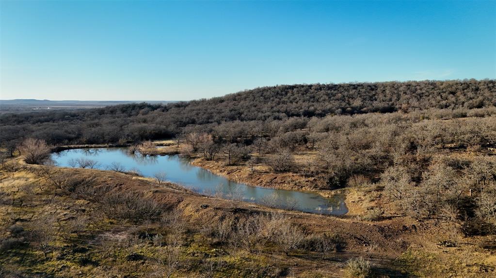 Welcome to an outdoorsman’s dream—an exceptional hunting and recreational retreat in the heart of Jack County. With extensive road frontage on two sides, this sprawling property is loaded with abundant wildlife, including deer, turkey, ducks, hogs, and coyotes, making it the perfect destination for avid hunters and nature enthusiasts alike.

A well-established trail system ensures easy access throughout the property, leading to three tanks. The largest, located at the front, is essentially a small lake, home to bass, crappie, and catfish—ideal for fishing and relaxation.

The land features over 150 feet of elevation change, with two prominent hills offering breathtaking views of the countryside. The west hill, one of the highest points in Jack County, provides a stunning vantage point to take in the beauty of the surrounding landscape. Most of the land is heavily wooded with towering oaks and mature timber, creating excellent cover for wildlife and a serene, secluded atmosphere.

A fully equipped hunting lodge sits at the front of the property, providing a comfortable retreat after a day outdoors. Just behind the lodge, a spacious shop offers ample storage for gear and equipment.

Whether you're looking for a prime hunting destination, a weekend getaway, or an investment in premier recreational land, this property offers unmatched potential.