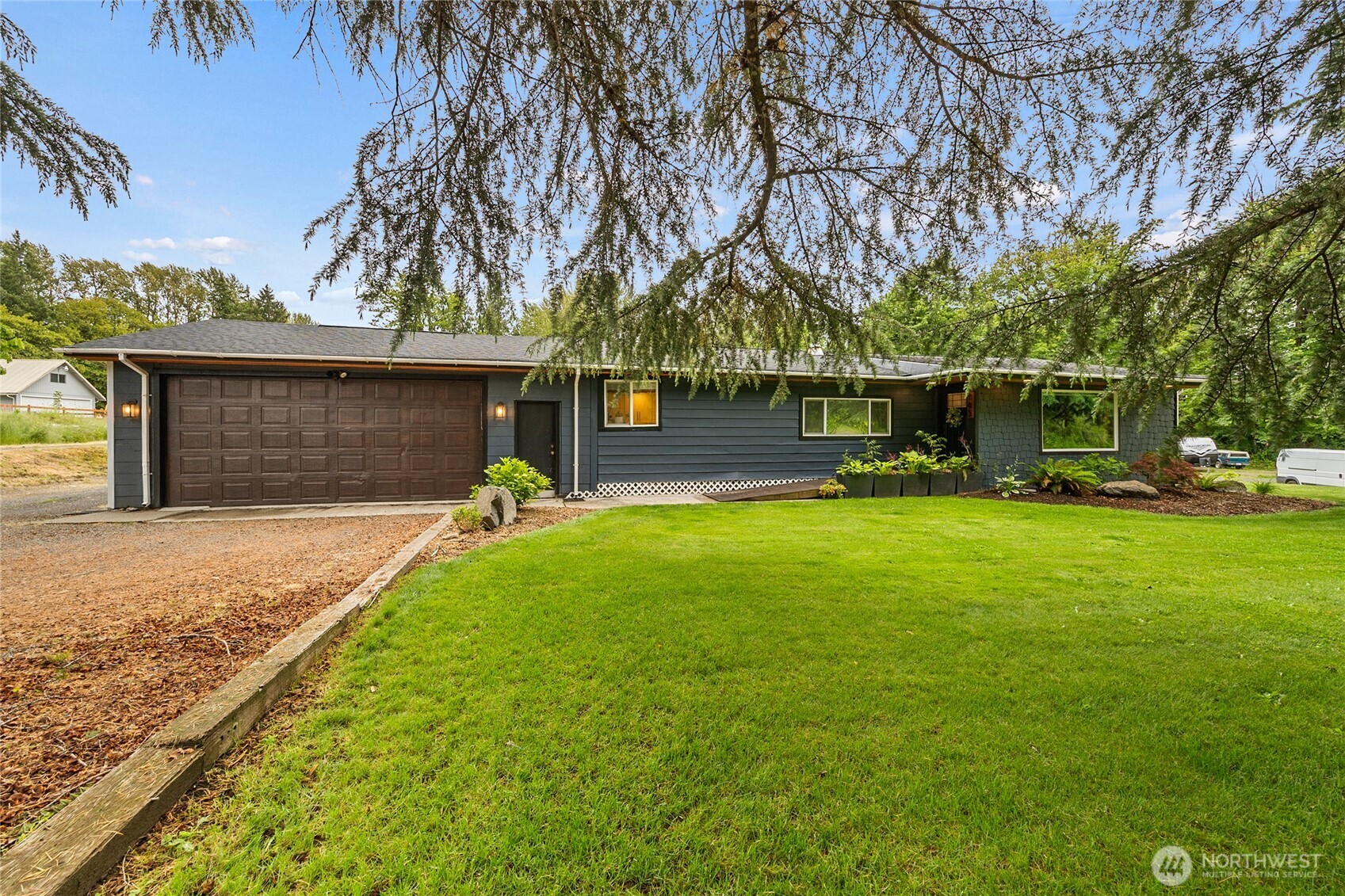 Beautifully updated country retreat on 2 acres in the heart of Randle. This 2-bedroom home blends modern comfort with rustic charm, featuring an open-concept layout, updated kitchen with quartz-style counters, stainless appliances, abundant cabinetry, and a cozy wood stove set against a stunning stone accent wall. The spacious living room offers vaulted ceilings, large picture windows, and a striking fireplace feature wall. The oversized primary suite includes a walk-in closet and peaceful views of the surrounding property. Enjoy year-round comfort with ductless mini-split heating and cooling, updated finishes throughout, and abundant natural light. Outside you'll find beautifully landscaped grounds, a large patio perfect for entertaining, greenhouse, detached storage/shop space, and plenty of room for gardening, recreation, RV parking, or future projects. Conveniently located near outdoor recreation, fishing, hunting, hiking, and all that the Gifford Pinchot National Forest has to offer.