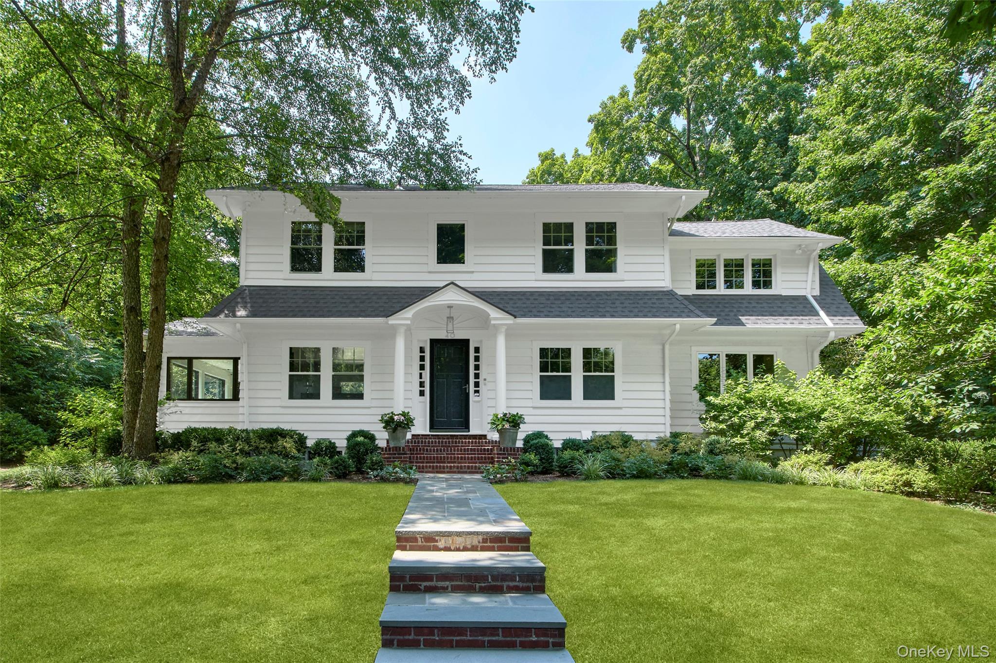 A truly exceptional offering, this picture-perfect 1930s Colonial blends timeless elegance with modern luxury.  Set on beautifully landscaped property in a serene setting yet just a moment away from town.   Impeccably maintained, tastefully expanded & renovated, the home showcases refined design, effortless flow, and enduring architectural charm.The main level is thoughtfully designed with a spacious, open layout—ideal for both everyday living and  entertaining. A welcoming foyer opens to a gracious living room with a fireplace and the oversized window frames the view to the back yard. The dining room flows seamlessly into the beautifully appointed chef’s kitchen, complete with a 48-inch Wolf range, Sub-Zero refrigerator, quartzite countertops, custom cabinetry, and a generous center island. Just off the kitchen, the family room offers a warm and comfortable setting for relaxing or casual gatherings. The versatile sunroom, with walls of windows and a slider to the patio is well suited for a sitting room, an office, or a play room.  A mudroom with custom built-in storage, a separate laundry room, and a stylish powder room enhance the home’s effortless, well-curated lifestyle.Upstairs, this 3-bedroom home lives like a 4-bedroom, offering exceptional flexibility. The expansive primary suite is a private sanctuary with abundant natural light, a spa like bath with soaking tub, separate shower, private water closet, dual vanities, and a dressing area with two walk-in closets. Two additional bedrooms, a full bath, and an office complete the second floor.Outside the property it truly magnificent—lush, level lawn framed by mature landscaping and specimen plantings create a rare sense of privacy and tranquility . A spacious patio extends the living space outdoors, perfect for dining, entertaining, or simply unwinding while enjoying the peaceful surroundings.  Ideally located just moments from town,  the train and schools, this home offers an exceptional blend of timeless elegance, modern comfort, and unmatched convenience.