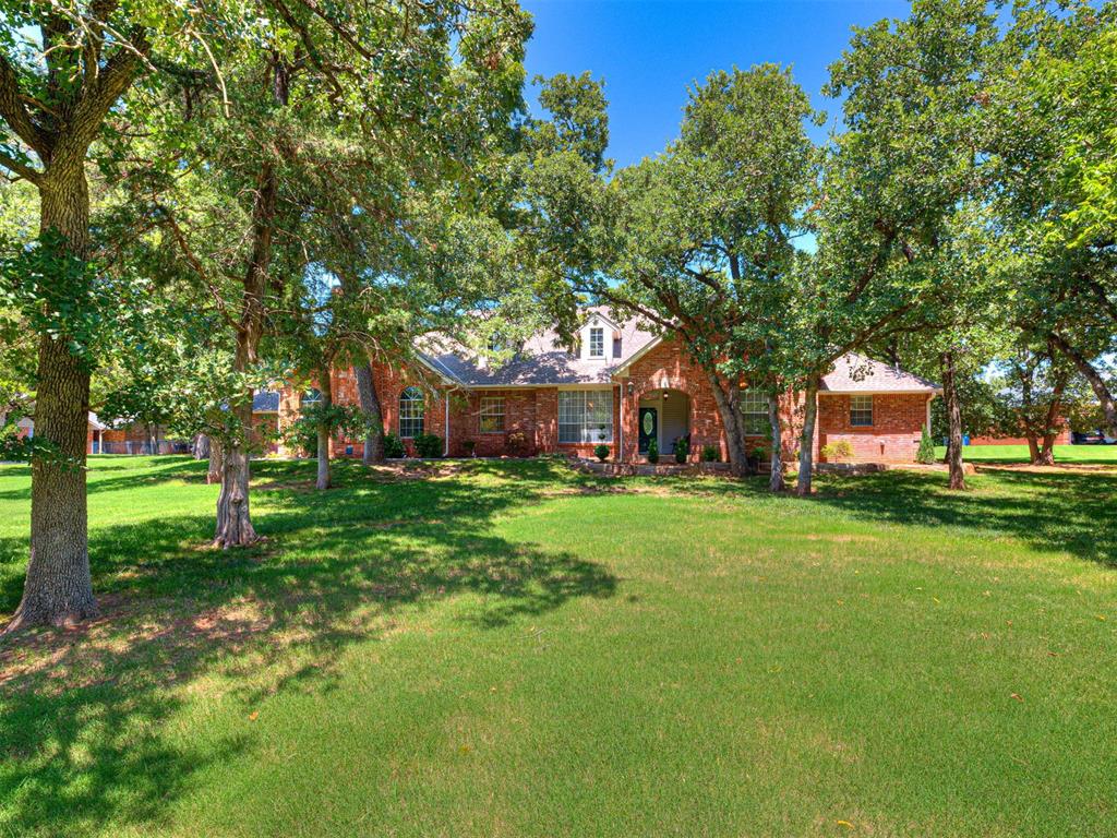 Tucked away in the serene landscape of Shadow Lake Estates, this lovely home is the peaceful retreat you have been looking for!  Wake up each morning ready to tackle the day knowing you have your own private sanctuary to return to in the evening.  Every room is oversized with style and warmth offering a canvas for creating a perfect space for entertaining family and friends.  The main living, complete with modern wine or beverage bar and fireplace, is bright and open to the formal dining, kitchen and breakfast area, featuring large windows for spectacular lush views of both the front and the back yard spaces.  The gorgeous updated kitchen is outfitted and ready for all of your culinary creations.  Escape to an exceptional primary suite with access to your very own coveted, screened porch!  Another huge, living room with fireplace, built-ins, stunning wall paneling and coffered ceiling is a flexible space for your study, homeschool, game room, theater room….you choose!   A guest bedroom suite with full bath and two other bedrooms with shared full bath, laundry room and plenty of storage complete the design.  On almost 1 & 1/2 acres, the lush backyard is full of beautiful trees, landscaping, and boasts a stone pathway, fire pit and plenty of living space to take your entertaining outside.  Located in Edmond Schools. Don't miss your country estate just minutes from everything North Edmond has to offer, call to schedule a tour today!