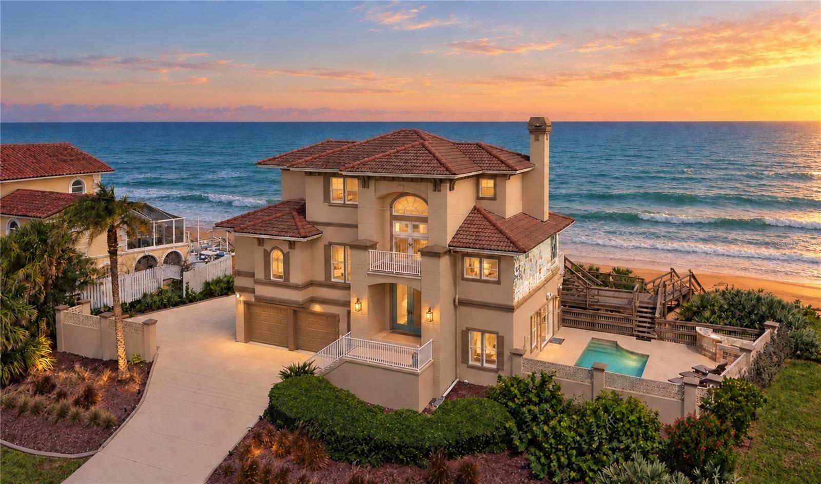 Set apart as one of the most distinctive oceanfront residences along this stretch of Flagler Beach, this coastal estate offers a rare combination of expansive grounds, privacy, elevated design and an exceptional relationship with the Atlantic Ocean. Encompassing approximately 0.64 acres with more than 100 feet of direct Atlantic Ocean frontage, the property is surrounded by preserved coastal dunes, mature palm trees and established landscaping. Concrete and stucco construction provide a sense of permanence and substance, with a timeless presence suited to its extraordinary setting. Offered furnished, the residence flows effortlessly between refined interiors and multiple levels of outdoor living. Expansive windows fill the home with natural light and frame panoramic ocean views throughout, while elevated decks and balconies create inviting spaces for morning coffee, dining and entertaining. A heated pool and private beach walkover extend the living experience through the dunes to the shoreline. The main level features gracious living, dining and family spaces, a beautifully designed kitchen, and a custom coffee and wine bar with wine storage and a wine refrigerator. A separate intimate gathering room offers a relaxed setting for coffee, wine and conversation. The third floor is dedicated to the primary suite, offering a private retreat with sweeping ocean views, its own balcony, a separate office and a private coffee bar. The primary bath introduces one of the home’s most memorable details, with a striking architectural window framing the Atlantic directly from the spa inspired shower, transforming an everyday ritual into an extraordinary experience. Recent improvements include three replacement HVAC systems serving each level, a new seawall, concrete fencing, decking on both levels, exterior electrical panels and refreshed exterior paint. The pool has also been enhanced with a new heater and pump, supporting year-round enjoyment of this private outdoor retreat. Ideally positioned along Florida’s northeast coast, the property offers exceptional access to historic St. Augustine, Daytona Beach and its renowned racing events, premier golf and country clubs including Hammock Dunes Beach Resort, and three conveniently accessible airports serving Jacksonville, Daytona Beach and Orlando. Walt Disney World, Universal Orlando Resort and Orlando’s world class attractions are approximately 1.5 to 2 hours away, while medical facilities, fine dining, shopping and everyday conveniences are all within easy reach. More than an oceanfront residence, this is a lifestyle defined by space, privacy, natural light and an ever-present connection to the Atlantic Ocean, offering the rare opportunity to wake to the sound of the waves, entertain against an unforgettable coastal backdrop and experience the rhythm of refined coastal living every day.