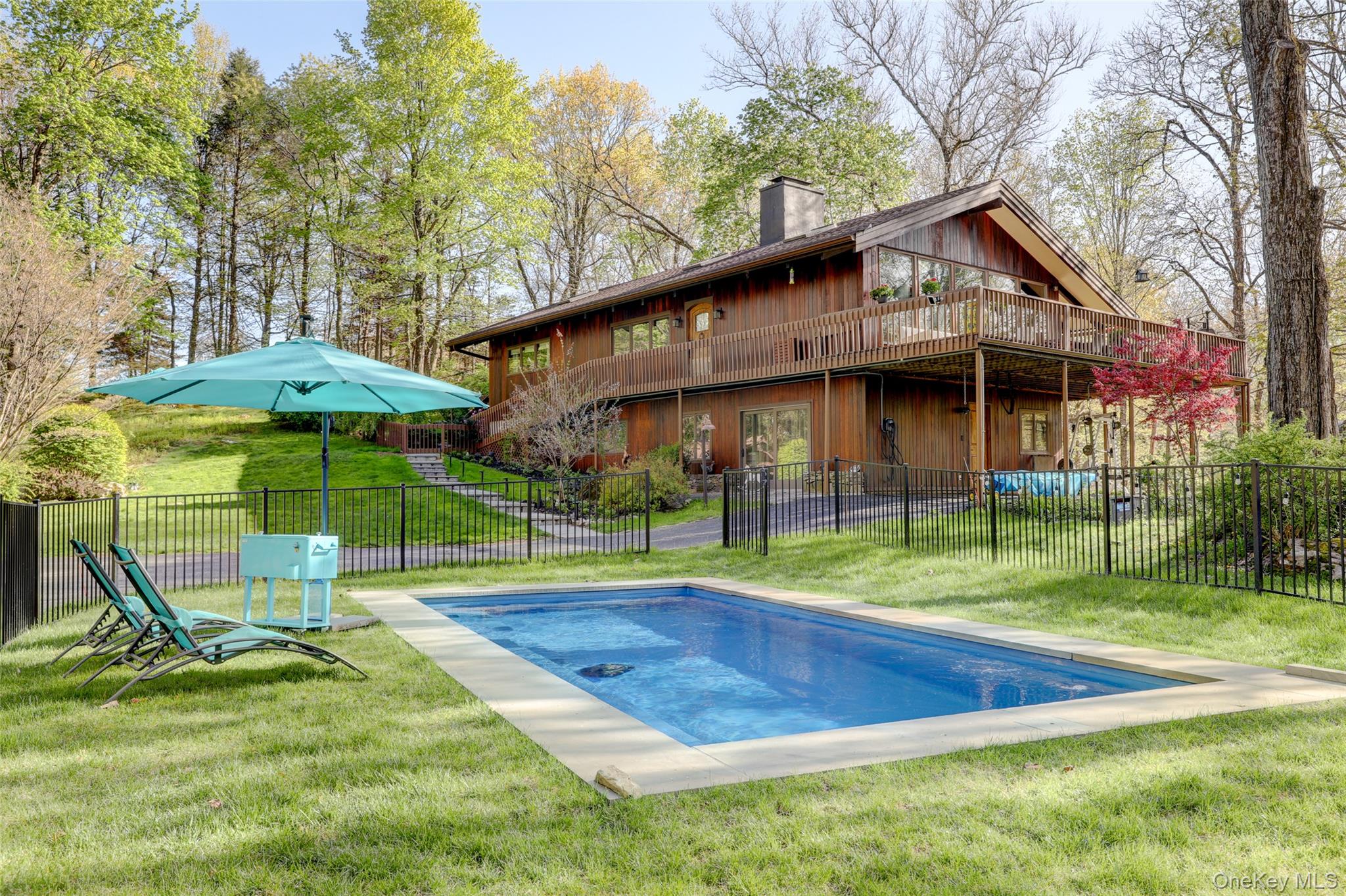 Nestled on two private acres, The Owl’s Nest is a striking 3-bedroom, 2-bath mid-century modern chalet that blends architectural character, privacy, and modern convenience. Surrounded by nature, the home feels like a secluded retreat while remaining easily accessible to nearby towns and commuting routes.The heart of the home is a dramatic living room with soaring 18-foot ceilings and wall-to-wall windows that flood the space with natural light and bring the outdoors in. Warm wood tones, clean lines, and custom doors reflect the timeless appeal of mid-century design, while wraparound, treehouse-like decks create a seamless indoor-outdoor living experience.Outside, the property features a pool, landscape lighting, and a traditional wood-fired sauna, creating a private oasis perfect for entertaining or quiet evenings under the stars.The home also includes upgraded systems throughout, including a modern boiler, water pump, smart home controls, and a full-house Kohler generator for year-round peace of mind.Conveniently located with easy access to the Merritt Parkway and Interstate 684, The Owl’s Nest is just 15 minutes from the train station in Stamford, with additional nearby access in Mount Kisco and Bedford Hills for convenient travel to New York City and beyond.More than a home, The Owl’s Nest is a private sanctuary with timeless design, modern comforts, and an extraordinary connection to nature.