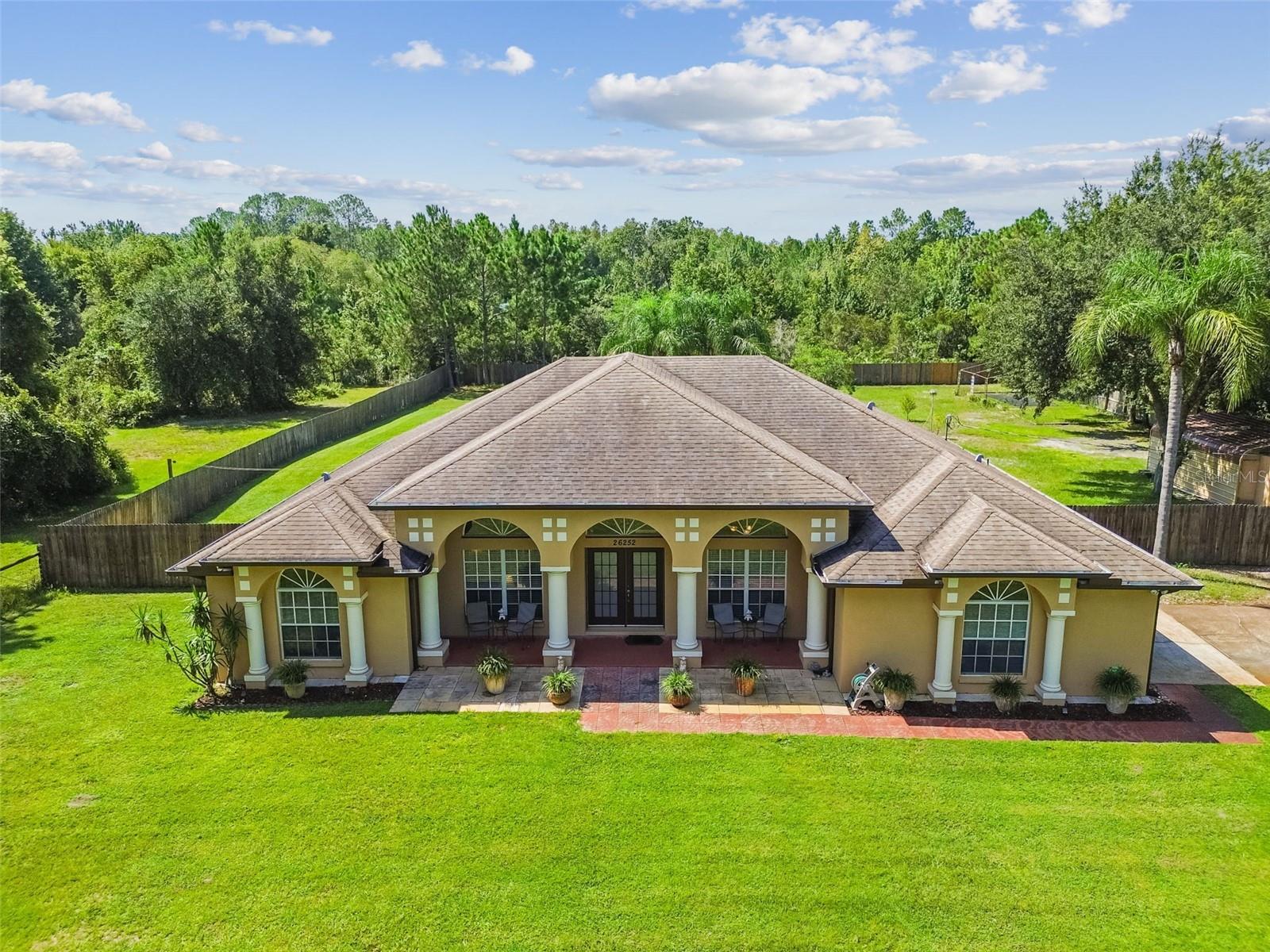 Welcome to this stunning and immaculately maintained estate situated on ONE ACRE in one of the
most DESIRABLE areas of Wesley Chapel. This Quail Hollow location features NO HOA and NO
CDD fees, this property provides the perfect blend of freedom, privacy, and convenience! This
ONE-OWNER HOME was intentionally built on an ELEVATED FOUNDATION, ensuring lasting
protection. Thanks to the added height, it has remained safe and dry through hurricanes and heavy
rains, with no flooding concerns from day one.
From the moment the long paved driveway leads to the grand DOUBLE GLASS DOOR ENTRANCE,
the curb appeal is undeniable. Step inside to soaring ceilings and a bright foyer that opens to the
formal living space, IDEAL AS AN OFFICE OR FLEX SPACE, and a large formal dining room perfect
for holidays and entertaining. Upon entering, views of the sparkling PRIVATE POOL and
EXPANSIVE BACKYARD framed by lush trees are showcased.
The SPLIT FLOOR PLAN IS A DREAM, offering three separate wings for ultimate FUNCTIONALITY.
The primary suite is a true retreat with a walk-in closet featuring CUSTOM BUILT-INS, dual vanities,
soaking tub, and walk-in shower. Two spacious secondary bedrooms share a guest bath in one
wing, while the third functions as a private suite with its own pocket door for separation.
Throughout the home, deep closets and AMPLE STORAGE maximize convenience.
The kitchen offers generous counter space, ample cabinetry, and a BREAKFAST NOOK overlooking
the pool. Outdoor living is equally impressive with a COVERED LANAI LARGE enough for dining
and lounging, a WET BAR, AND A SPACIOUS POOL DECK. The pool was NEWLY RESURFACED
WITH A NEW POOL LIGHT (2022, $7,000).
Recent upgrades provide peace of mind, including a BRAND-NEW HVAC SYSTEM (2024, $10,500),
NEW HOT WATER HEATER (2025), NEWER EXTERIOR PAINT (2022, $5,000), NEWER POOL PUMP
(2022), AND HURRICANE SHUTTERS ($9,300). Additional features NO CARPET, along with a whole-
home central vacuum, GUTTERS, WATER FILTRATION SYSTEM, a detached shed/workshop
engineered for 130 MPH winds WITH ELECTRIC, a greenhouse for gardening enthusiasts, and a
backyard GAZEBO WITH ELECTRIC for quiet relaxation.
ZONED AGRICULTURAL, this property offers unique flexibility. Animals are welcome, making it an
ideal space for those who want room for pets, small livestock, or simply to enjoy the freedom and
possibilities that come with agricultural zoning.
This property combines FUNCTIONALITY WITH UNMATCHED OUTDOOR LIVING on a FULLY
FENCED ACRE offering endless possibilities.
Location is UNBEATABLE, tucked away on a quiet street yet just minutes from I-75 and I-275, The
Grove, KRATE, the highly anticipated NEW TARGET, best hospitals, shopping, dining, and top-rated
schools. This rare opportunity offers the best of both worlds, serene private living with unmatched
proximity to everything Wesley Chapel has to offer. COME HOME!