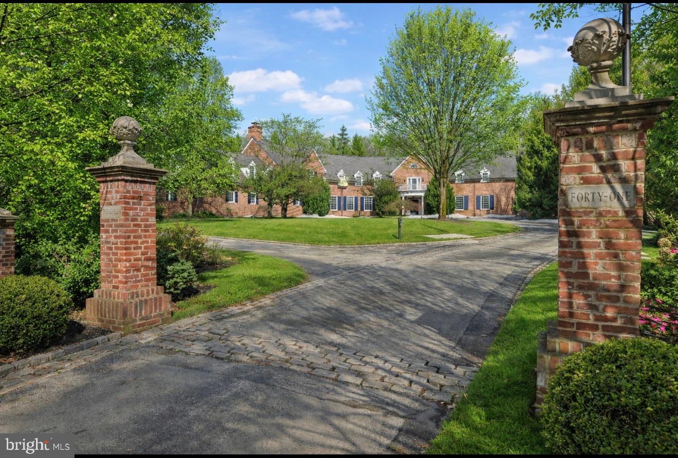Located in the desirable Merion Golf neighborhood, this stately brick estate sits on a private, level 2.26 acre lot, one of the best lots in the neighborhood! Built in 1999 by EB Mahoney, this home offers a rare opportunity where homes are seldom available. The home features 5-BR, 6-full bath, 5-powder rooms—including a separate upstairs guest suite with kitchenette and sitting room. The magnificent grounds feature an in-ground heated pool and hot tub, outdoor kitchen, pool bath, expansive patios, a covered porch, and fire pit, all designed for an unparalleled indoor-outdoor lifestyle.Stone pillars adorn the entrance to a circular drive leading to 5 total garage spaces: a side-entry 2-car garage with workshop and a rear-entry 3-car garage with radiant floors. The 8,374 sq ft interior offers an expertly designed floor plan. A grand foyer opens to the living room with soaring ceilings, a gas fireplace, and a wet bar with sink and ice maker. The elegant dining room offers custom built-ins. Both rooms have French doors leading to the covered patio. A formal powder room is located here.The front hall, past the formal rooms, leads to the kitchen. This culinary space features marble countertops, a walk-in giant pantry, and a premier Gaggenau appliance suite (2 wall ovens, 1 steamer, microwave, and warming drawer). Premium additions include a Thermador 5-burner range, Miele dishwasher, and a Sub-Zero refrigerator/freezer with Reverse Osmosis (RO) filtered water and ice. A RO water tap is located at the kitchen and bar  sinks. A well appointed Butler’s Pantry features a Dacor wine tap, Sub-Zero dual-zone red & white wine fridge, 3 Sub-Zero beverage drawers, RO ice maker, and dishwasher. This entire wing is a superb entertaining space, as the sun-filled breakfast room with an aquarium flows seamlessly into an expansive family room with a white brick fireplace and a handsome staircase to the lower level.The private main floor primary wing bedroom features a gas fireplace and French doors to the pool. "Her" ensuite offers a custom walk-in closet, and a spa-like bath with radiant heated floors, whirlpool tub and frameless glass shower. "His" suite features a custom closet with island and a private bath with radiant floors, RO water, and a direct french door for pool access.Off the kitchen, the main floor has an Office (1 of 2) and informal powder room. A mudroom with built-ins, and back stairs provides garage access.At the top of the foyer stairs, the right wing is a dedicated retreat featuring an Executive Office with soaring ceilings, plus a private entertaining room with a wood-burning fireplace. A powder room with built-in sauna is plumbed for a shower. The entertainer’s bar in this room includes a fridge, dishwasher, and RO water, and a warming drawer.  Both rooms access the balcony. Stairs also lead to the side garage.The left wing offers 3 ensuite bedrooms, one of which is a unique 2-story suite featuring a spiral staircase to a lofted sleeping area. In addition, there is also a private guest/in-law suite complete with a sitting room, kitchenette, bedroom #4, and a full bath. It is easily accessed via the back stairs.The 2,200 sq ft finished lower level is an expansive destination featuring a recreation room, game room, wine cellar, exercise area, laundry, and powder room. Utility and storage rooms provide ample space, while the unfinished area has a convenient exterior exit. For peace of mind, the home is wired for Lutron lighting, includes a whole-house generator and a 4-pump water management system. Located just a stroll from the world-renowned Merion Golf Club, this estate offers an unparalleled lifestyle with premier Main Line access. Commuters will appreciate easy access to Haverford and Ardmore SEPTA/Amtrak stations for quick trips to Center City and NYC. Minutes from shopping at Suburban Square and in the Haverford Twp School District, this home is perfectly positioned for an exceptional lifestyle.