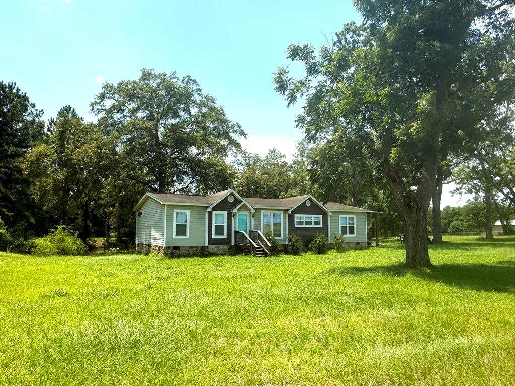 Come check out this three-bedroom, two-bathroom double-wide mobile home. Situated on 5 acres in Colquitt County. The property features a small pond, a spacious kitchen with a central island, an open concept layout, a large laundry room, dining room area, and a covered side porch measuring approximately 16 x 20 feet, providing ample space for outdoor grilling and relaxation. Storage building included. The property is located on a grated gravel road and offers a serene and secluded environment. Contact an agent today to schedule a viewing of this exceptional property.