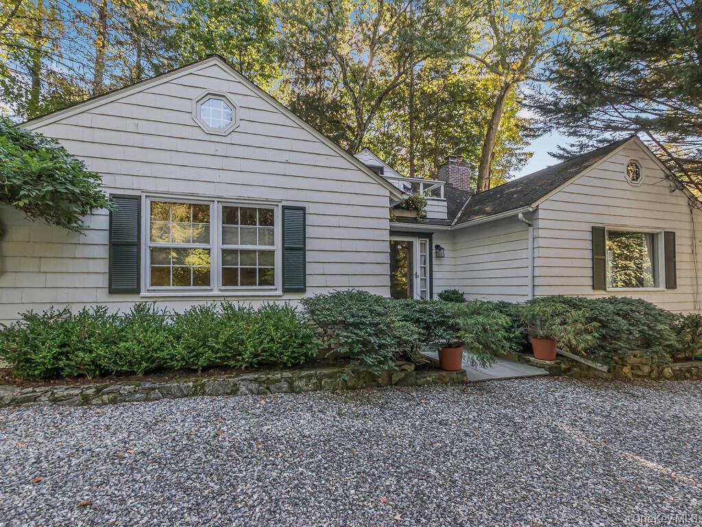 .Welcome to this unique and charming carriage home nestled in the heart of Chappaqua. Legally 2BR but lives as 3 BR with permitted additions. Bright and sunny, set on a private 0.69-acre lot. This well-maintained residence blends timeless character with modern updates. Step inside to a welcoming entry foyer that leads to a spacious living room, complete with a cozy fireplace and French doors opening to a secluded patio — perfect for entertaining or quiet relaxation. The country-sized kitchen has been thoughtfully updated, featuring an informal seating island and space for a full dining table, making it the true heart of the home. Off the kitchen, a lovely pergola extends your living space outdoors. The main floor offers a primary bedroom along with two additional versatile rooms — currently used as a family room and office but true bedrooms— plus an updated full bath and half bath . Upstairs, discover a loft-style master suite with its own private bath and French doors leading to a private balcony, creating a serene retreat. Additional highlights include parking for up to four cars, mature landscaping, and the privacy of a wooded setting, all while being minutes from Chappaqua’s schools, train station ( 1.2 miles), and town center.