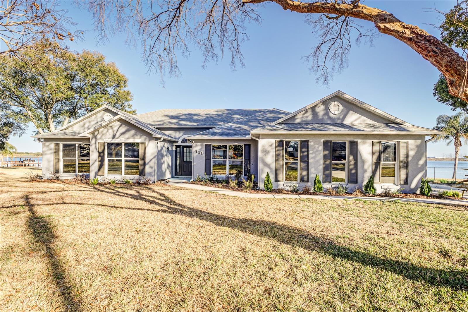 Lakefront living on nearly an acre—welcome to 411 Edgewater Dr. in Polk City. Set on a rare .83-acre waterfront lot with approximately 205 feet of frontage on beautiful Lake Agnes (home to Fantasy of Flight), this fully updated pool home is the kind of Florida lifestyle property that doesn’t come around often.  Step out back to a screened-in pool and expansive lake views with an eastern exposure—perfect for sunrise coffee, bright mornings on the water, and shaded afternoons by the pool. With ample shoreline, the buyer has the opportunity to add a private boat dock and truly create the ultimate lakefront retreat.  Plenty of parking with space for a boat or RV.  Inside, the home is turn-key and move-in ready with tasteful updates throughout. Energy film on the windows helps reduce heat load and glare, keeping the interior comfortable while preserving those incredible water views.  Conveniently located between Lakeland and Orlando with quick access to I-4, you’re positioned for easy commutes to Orlando, Lakeland, and Tampa—and it’s also just about a half-hour drive to Walt Disney World Resort—while still enjoying the peace and space of lakefront living.