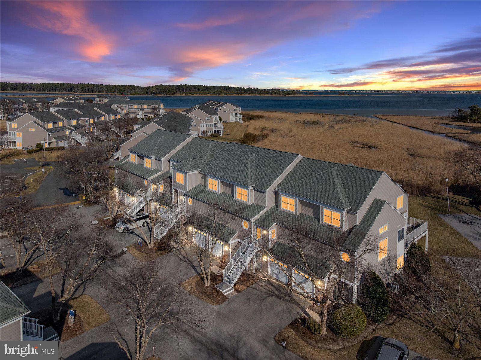 338312 Ocean Vista Drive #1082 in Selbyville, Delaware is a waterfront townhome in the desirable Bayville Shores community offering expansive views of the Little Assawoman Bay, surrounding wetlands, and the Fenwick Island skyline just minutes from the beach. This 3-bedroom, 3.5-bath residence features a light-filled open-concept main level with detailed trim work and a spacious granite island kitchen designed for entertaining and easy coastal living. Sliding doors lead to an open waterfront deck where you can enjoy peaceful morning sunrises over the bay, coastal breezes, and ever-changing natural scenery. The upper level offers a generously sized primary suite with a private deck overlooking the water—an ideal vantage point for sunrise skies—along with exceptional closet space rarely found in similar properties, while an additional en-suite bedroom provides comfort and privacy for guests. The entry-level suite opens to a covered patio and green space, creating flexibility for visitors, extended family, or a secondary living area. A conveniently located laundry area and attached garage with added storage enhance everyday functionality and beach-day convenience. Ownership is designed for ease, with the HOA covering exterior maintenance as well as flood and hazard insurance, while water service is included and the home is connected to public sewer. Residents also benefit from low electric rates through Delaware Electric Cooperative, and Bayville Shores incorporates community solar that has generated more than 1.5 million kilowatt hours of energy over time. Community amenities include a private boat ramp, kayak and paddleboard launch, pool, tennis courts, and scenic walking paths, all ideally located between the Freeman Arts Pavilion and the beaches of Fenwick Island. Short-term rentals are permitted, making this property equally attractive as a primary residence, second home, or strong coastal investment opportunity. Updates include a new hot water heater.