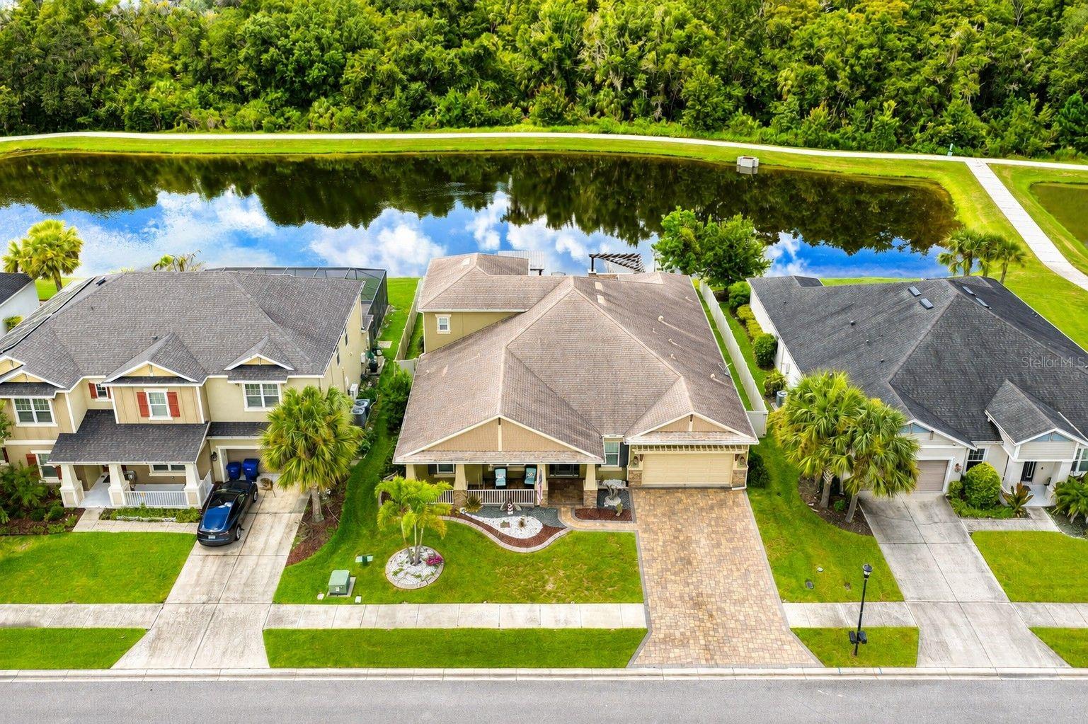 Virtually Staged. LIKE A MODEL – UPGRADES GALORE! Absolutely stunning and move-in ready, this beautifully upgraded waterfront home is located in the highly sought-after gated community of ARBOR WOODS, offering NO CDD fees, low HOA fees, scenic ponds and trails, a community pool, and playground. Perfectly positioned on a beautifully landscaped large waterfront lot along a quiet street, this exceptional two-story residence offers an impressive 3,707 sq. ft. of living space with 5 bedrooms, 3 full baths, 2 half baths, a dedicated office, huge bonus room, and oversized 3-car garage. Designed for both everyday comfort and entertaining, this home combines luxury, space, and thoughtful upgrades throughout. Step through the welcoming foyer into a bright, open floor plan featuring soaring ceilings, elegant tray ceilings, abundant natural light, and beautiful tile, luxury vinyl, and wood flooring throughout—NO CARPET! The spacious formal dining room provides the perfect setting for family gatherings and dinner parties.At the heart of the home is the spectacular chef's kitchen, beautifully designed for entertaining and everyday living. Features include gorgeous 42-inch custom cabinetry with crown molding, granite countertops, oversized center island, designer tile backsplash, upgraded stainless-steel appliances, gas range with pot filler, custom vented range hood, built-in double oven and microwave, deep stainless-steel sink, under-cabinet lighting, breakfast bar, coffee bar, walk-in pantry, and spacious casual dining area.Retreat to the luxurious owner's suite featuring elegant crown molding, a tray ceiling, custom walk-in closet, and spa-inspired ensuite bath with dual vanities, an oversized custom-tiled walk-in shower, and relaxing garden soaking tub. The 4th bedroom is currently being utilized as an incredible custom dream closet and can easily be converted back to bedroom use. Additional spacious bedrooms and beautifully appointed guest baths provide plenty of room for family and guests, while the dedicated office creates an ideal work-from-home space.The downstairs game room offers excellent flexibility and can easily function as a 5th bedroom. Upstairs, the massive bonus room features a wet bar, refrigerator, and half bath, creating the perfect space for a home theater, game room, playroom, entertainment lounge, or man cave.The expansive family room opens through sliding glass doors to an incredible private backyard oasis with stunning waterfront views. Thoughtfully designed for year-round relaxation and entertaining, the expansive paver lanai features a full outdoor kitchen, fire pit, covered seating area, open patio space, waterfront swing, and beautiful tropical landscaping. Whether enjoying your morning coffee, hosting BBQ's, or relaxing by the water at sunset, this backyard was designed to be enjoyed. Additional premium features include permanent exterior holiday lighting, surround sound, central vacuum, crown molding, tray ceilings, upgraded lighting, ceiling fans, and much more!This exceptional home offers the perfect combination of luxury, comfort, space, and resort-style Florida living in one of Wesley Chapel's most desirable communities.Conveniently located near I-75 and I-275, Tampa International Airport, Downtown Tampa, Tampa Premium Outlets, The Shops at Wiregrass, KRATE at the Grove, hospitals, schools, golf courses, shopping, dining, and entertainment. CALL US TODAY FOR A PRIVATE SHOWING!