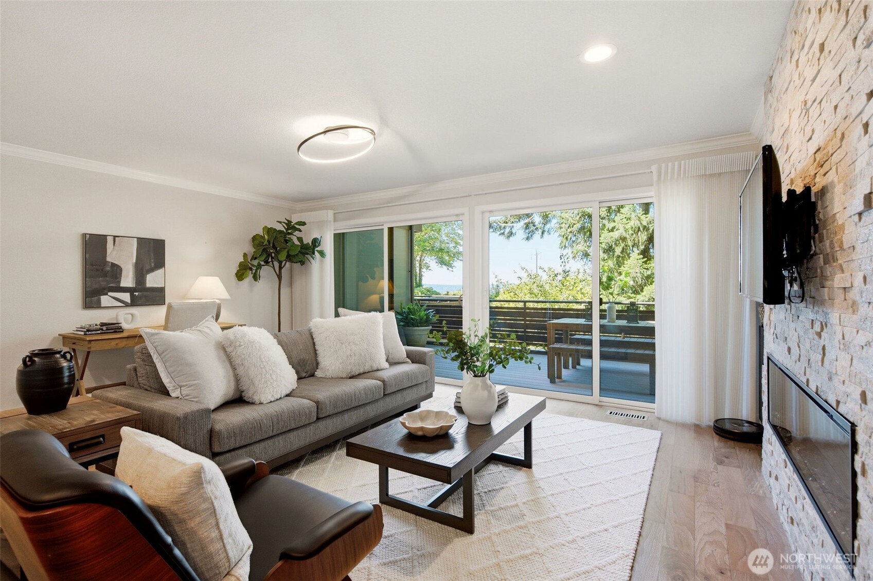 Cozy gathering space highlighted by expansive windows and a striking fireplace.