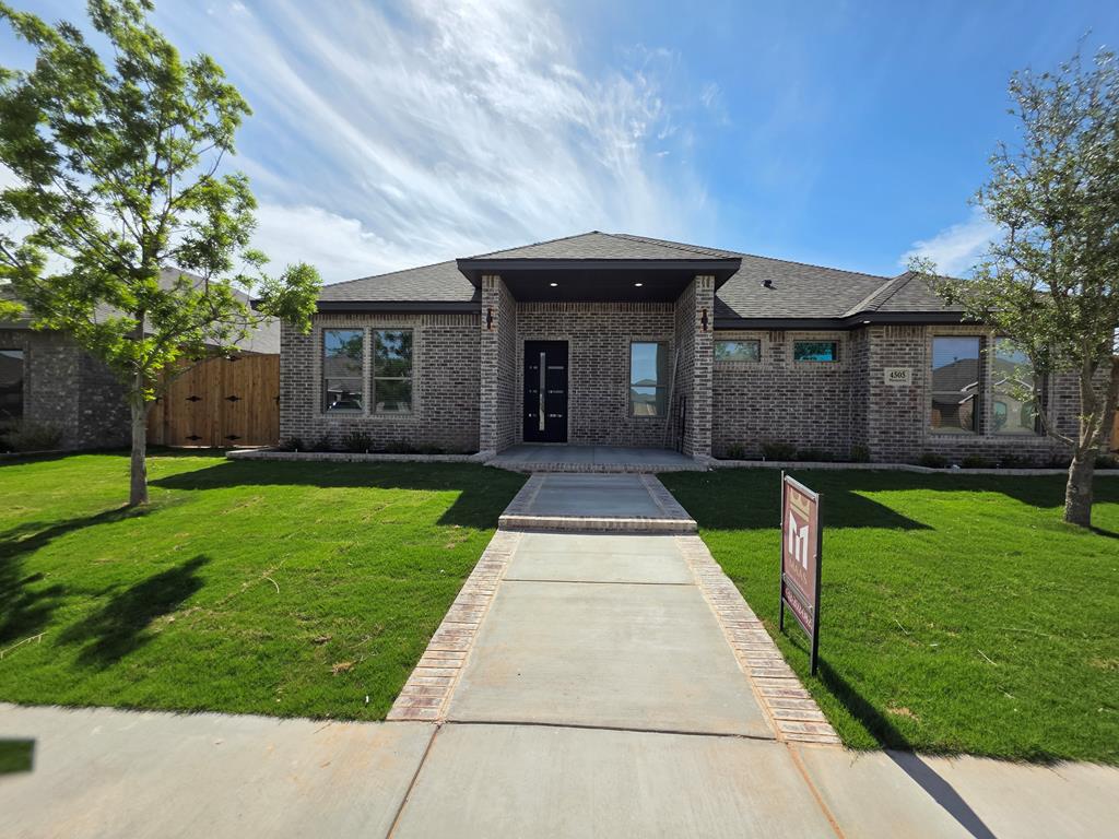 This home is a thoughtfully designed living space across 4 bedrooms and 2 bathrooms. The open-concept living area immediately commands attention with its dramatic vaulted ceilings, recessed lighting, a contemporary chandelier, and a ceiling fan. A floor-to-ceiling dark fireplace surround serves as a bold focal point, complemented by light, large-format tile flooring.  The kitchen is outfitted with white shaker cabinetry extending to the ceiling, a solid surface island and stainless appliances.  The spacious master suite has a spa inspired bathroom, with a jetted tub and large closet.