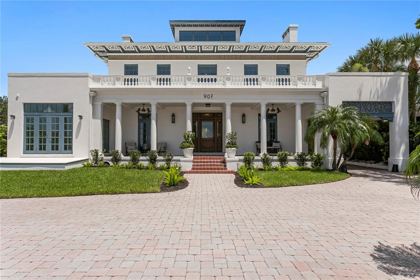 Commanding a distinguished position along celebrated Bayshore Boulevard, this extensively remodeled stately Neoclassical residence presents an extraordinary expression of timeless architecture, superior craftsmanship and modern luxury. Known as the Isaac Maas House, the 1923 residence pairs authentic period provenance with an extensive 2021 renovation designed to deliver the systems, functionality and finishes expected for modern luxury living. Framed by an elegant circular paver drive, gas lanterns and a gracious columned portico, the home captures magnificent views across Tampa Bay from the front veranda and throughout the home. The interiors unfold with refined finishes, hardwood flooring, statement lighting, coffered ceilings and extensive custom millwork. A wood-paneled study with humidor, formal dining room, family room including an adjoining butler’s pantry with Dacor wine station and wet bar, and sunroom with veranda and courtyard access create an inspired collection of living and entertaining spaces. French doors and transom windows introduce abundant natural light while creating a graceful connection between the elegant interiors. At the heart of the residence, the impressive chef’s kitchen is designed for both culinary brilliance and effortless entertaining. A statement La Cornue range and custom hood take center stage, complemented by multiple prep sinks, Thermador appliances, dedicated beverage storage, plumbed coffee maker and walk-in pantry. Upstairs, the serene primary retreat captures breathtaking bay views and features an expansive custom closet/dressing room. The spa-inspired bath offers a luxurious wet room with a deep soaking tub, steam shower and decadent finishes. The second level also offers two additional guest bedrooms with ensuite baths, a media room and custom built-ins designed to complement the home’s original architectural character. The third floor offers finished flex space along with generous storage and extraordinary elevated views stretching across Bayshore Boulevard to the sparkling waterfront. Outdoors, a private oasis with courtyard and lush tropical landscaping awaits. The heated pool and spa, enhanced by a tranquil waterfall feature, provide an intimate resort-inspired setting for relaxation and entertaining. A pull-through two-car garage with alley access is topped by private guest quarters featuring a kitchenette, full bath and walk-in closet, ideal for extended stays or flexible living arrangements. Completed in 2021, the extensive renovation went well beyond cosmetic finishes. Working with an architect and structural engineers, the residence was taken to the studs and its interior floor plan comprehensively reimagined. Steel beams were incorporated to create more open, light-filled living spaces and a natural flow among the kitchen, family room and entertaining areas. Plumbing, electrical and flooring were replaced and a new roof installed, with impact-rated windows and doors, three-zone HVAC, Control4 home automation and automated window shades integrated throughout. The result preserves the architectural character and provenance of this distinguished 1923 residence while delivering the infrastructure, technology and functionality of contemporary luxury living. Blending historic distinction with commanding bay views and an iconic address, this remarkable residence offers an incomparable Tampa lifestyle moments from acclaimed dining, shopping, arts and culture, sports, downtown and airport.
