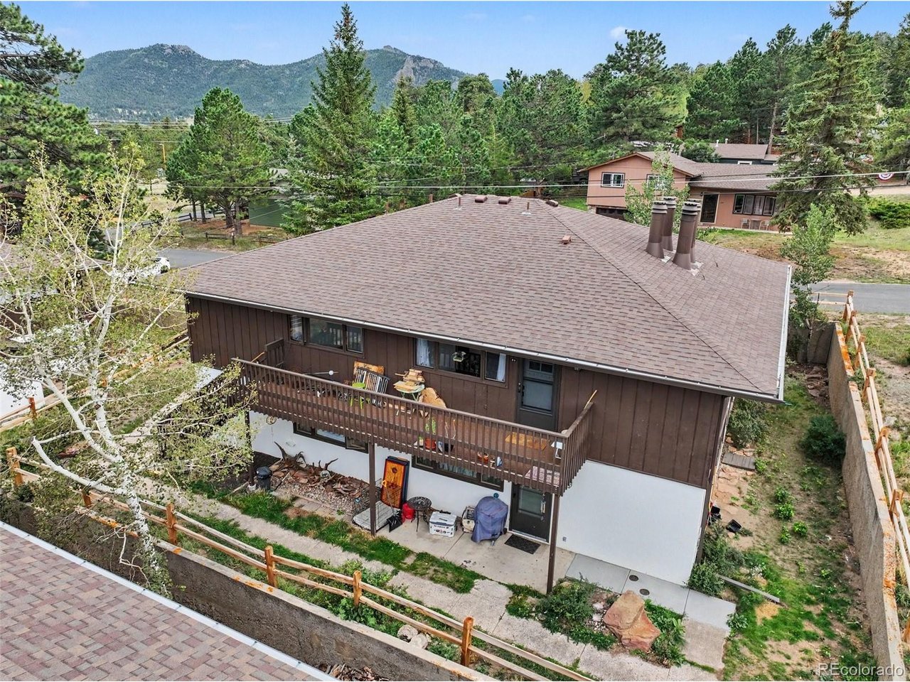 Incredible opportunity in the heart of Estes Park! This top-floor unit offers a bright and cheerful open living space designed for comfortable mountain living. A beautiful brick fireplace creates a warm and inviting focal point, perfect for cozying up during Colorado winters. The kitchen features modern stainless steel appliances, ample warm wood cabinetry, and plenty of space to prepare your favorite meals. A dining nook and breakfast bar provide flexible seating for everyday dining and entertaining. The spacious primary bedroom offers two closets, while the second bedroom is ideal for guests, a home office, or additional living space. Premium luxurious vinyl floors are easy to clean and look fantastic! Step outside onto the large deck and enjoy the fresh mountain air. Open space behind the home provides room to stretch your legs with Fido, while nearby picnic tables offer an easy spot for outdoor dining. A common laundry area adds everyday convenience. Enjoy an unbeatable Estes Park location within walking distance of downtown dining and shopping, plus easy access to nearby golf courses and Lake Estes, where a scenic trail circles the lake. And best of all, iconic Rocky Mountain National Park is just minutes away! Move right in and start enjoying the mountain lifestyle, outdoor adventure, and small-town charm that make Estes Park such a special place to call home.